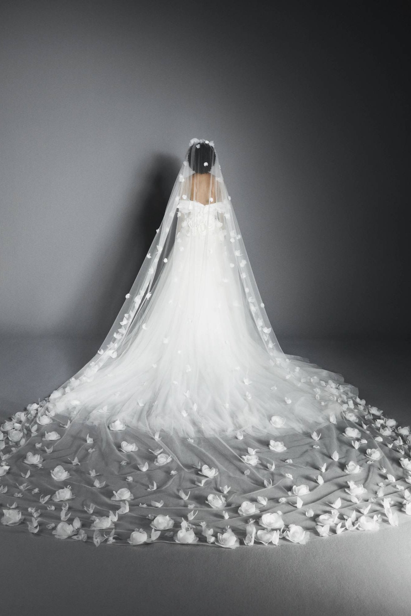 Dramatic veil adorned by beautifully crafted organza flowers, depicting a romantic garden on a sheer tulle canvas, from the Viktor&Rolf Mariage collection.