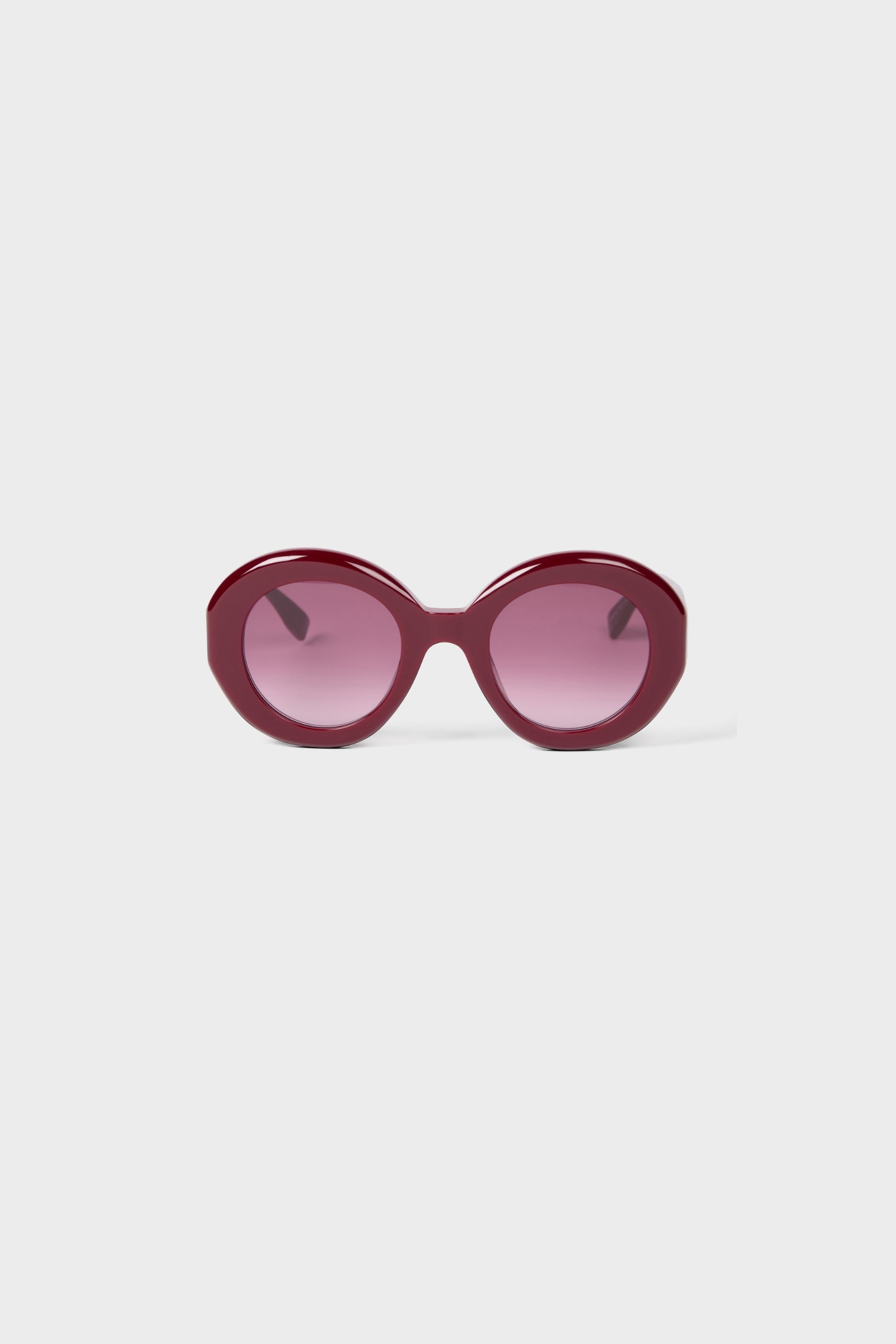Burgundy round glasses on a white background.