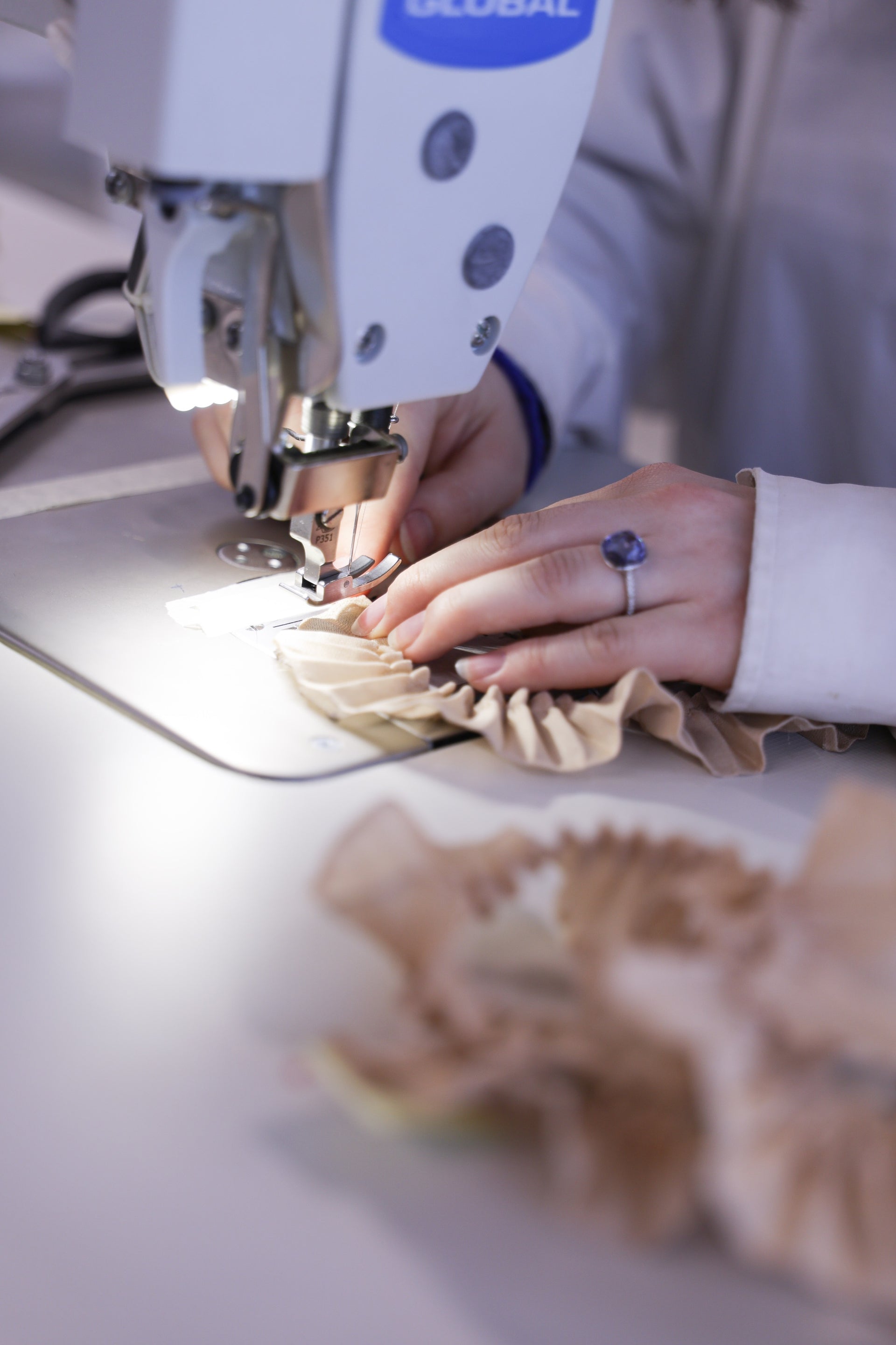 Close-up on a person's hands working on a design in an atelier.