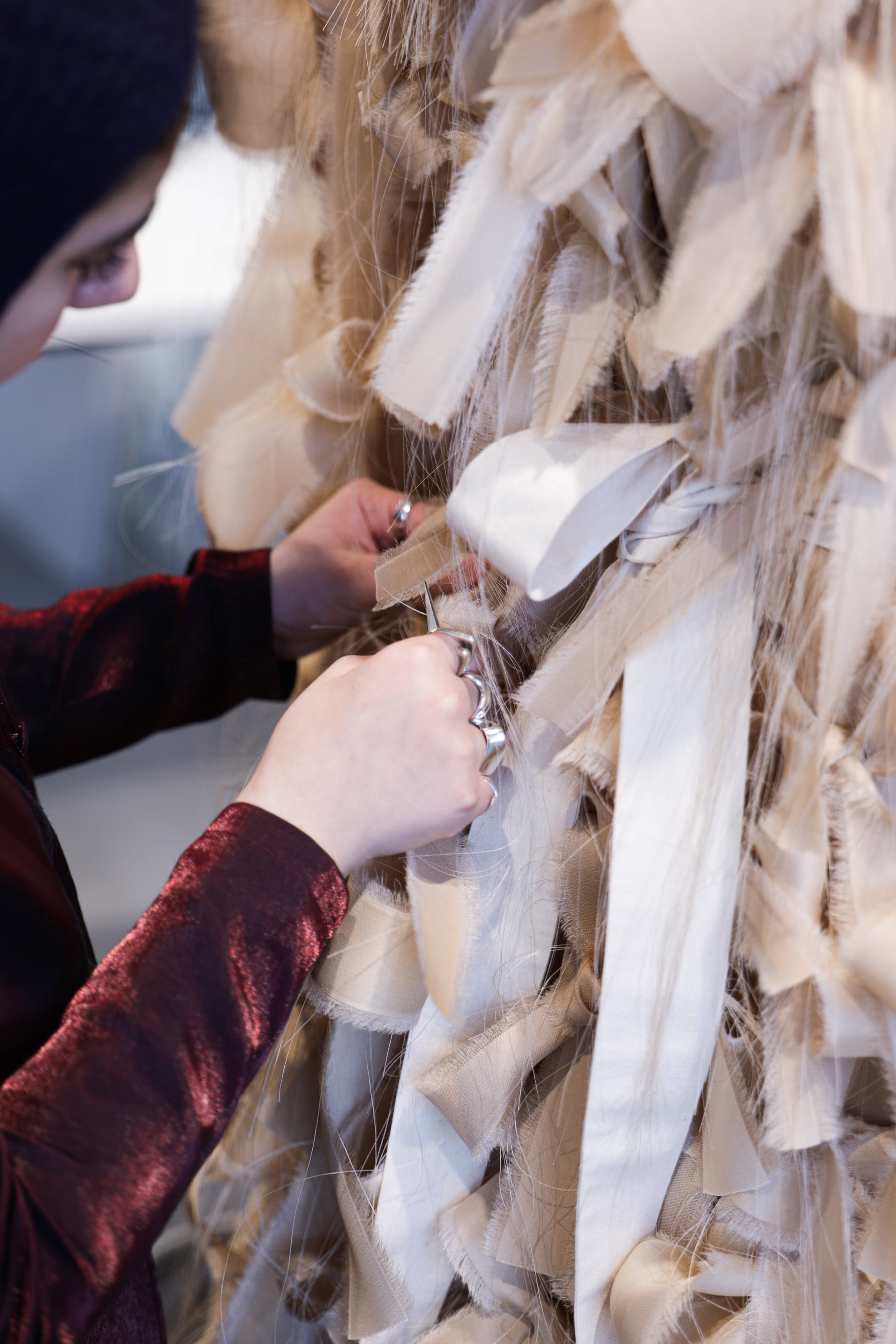 Close-up on a person's hands working on a design in an atelier.