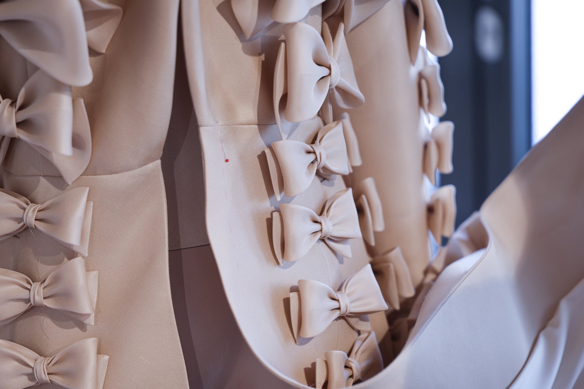 A close-up on bow details of a beige garment.