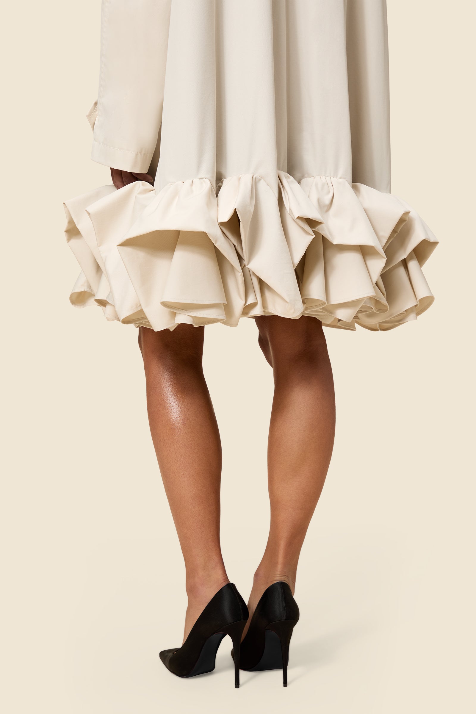 The craftmanship of the trenchcoat reinterprets classic haute couture tuck ups into a modern silhouette from gabardine