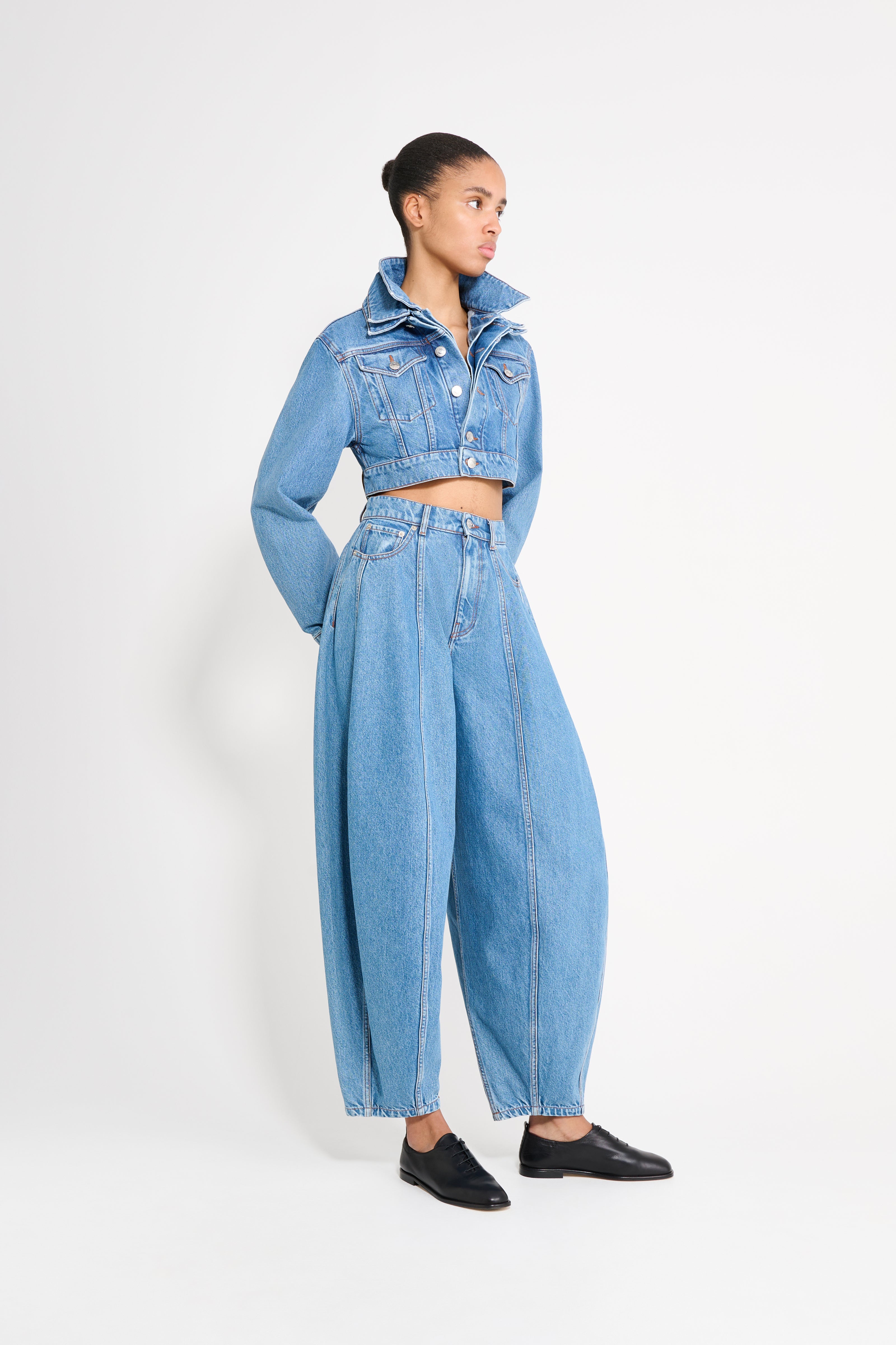 Person wearing a blue denim outfit on a white background