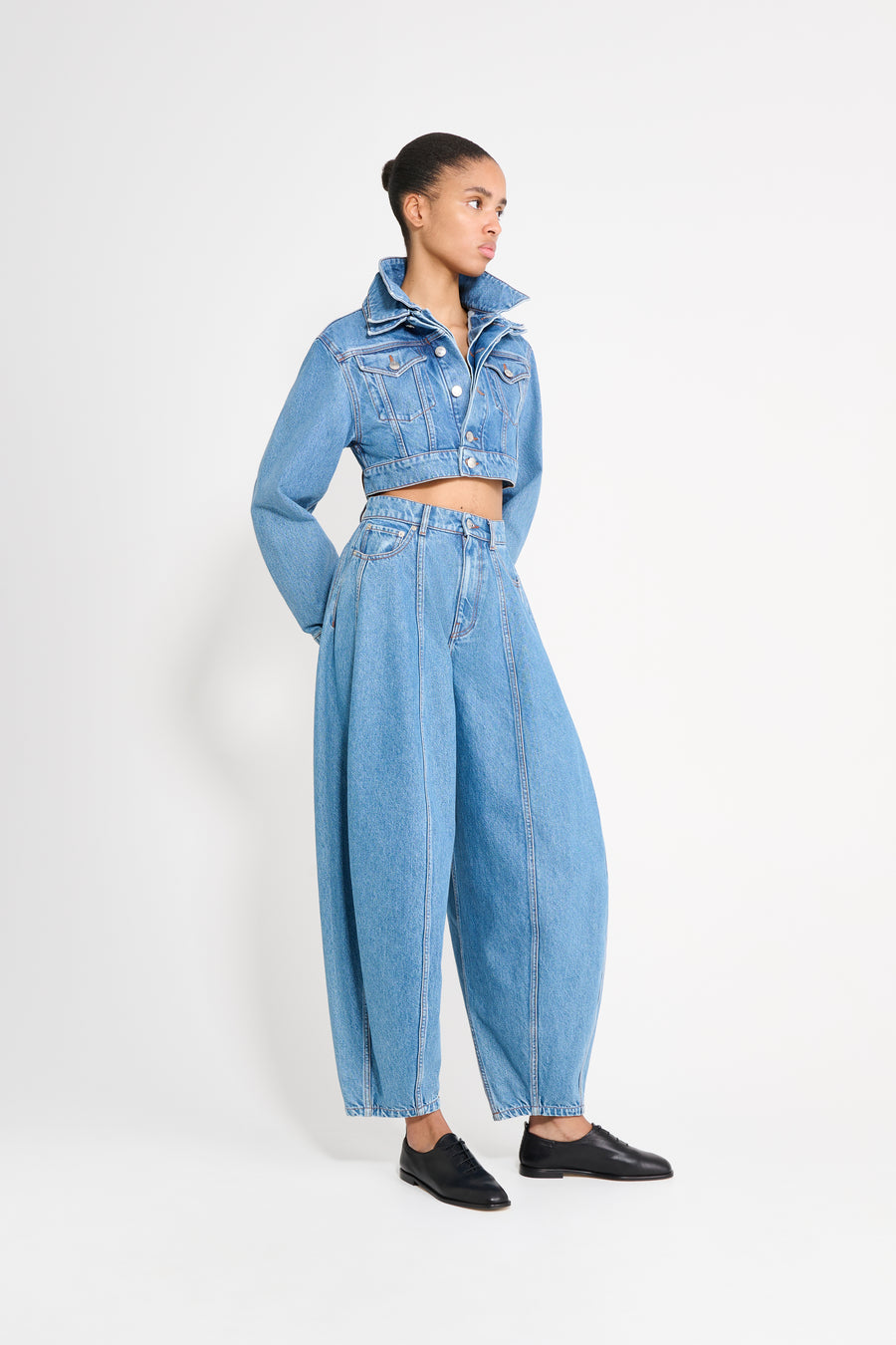 Person wearing a blue denim outfit on a white background