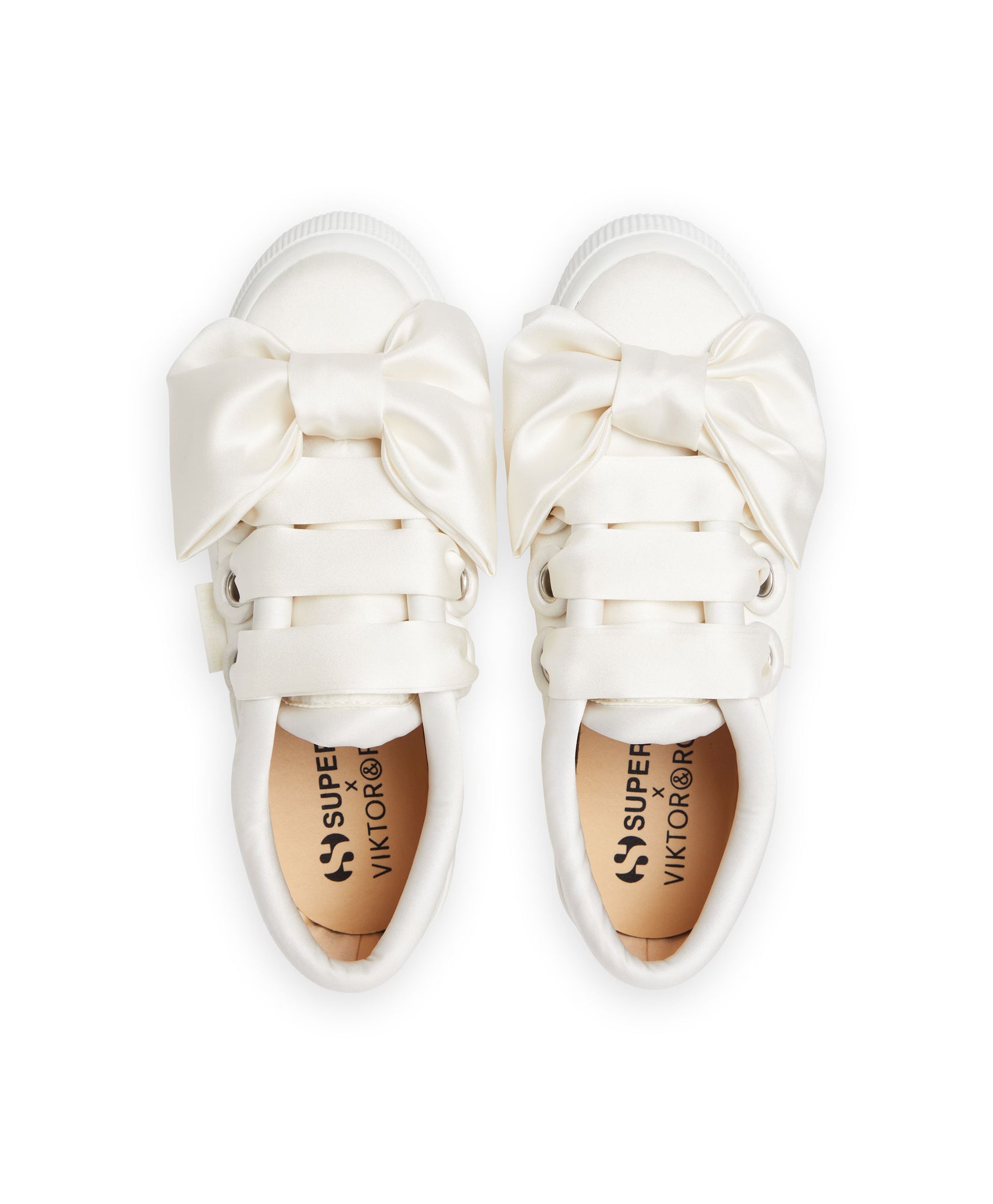 Luxurious white satin sneakers featuring elegant oversized bows and intricate strap detailing for a chic, stylish look.