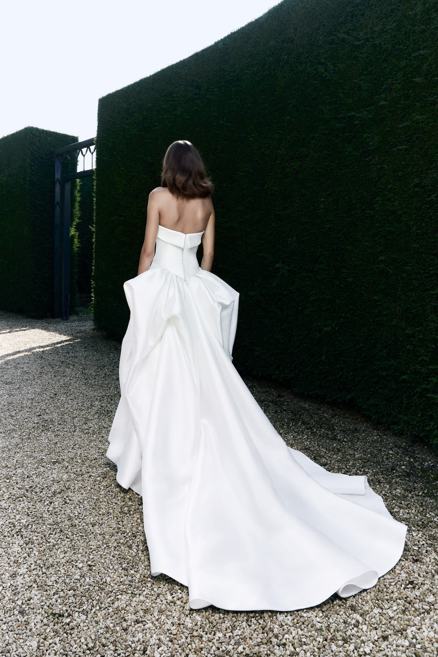 Viktor & Rolf Mariage Bridalwear Collection, strapless white gown from Autumn Winter 25 featuring elegant ruffled train.