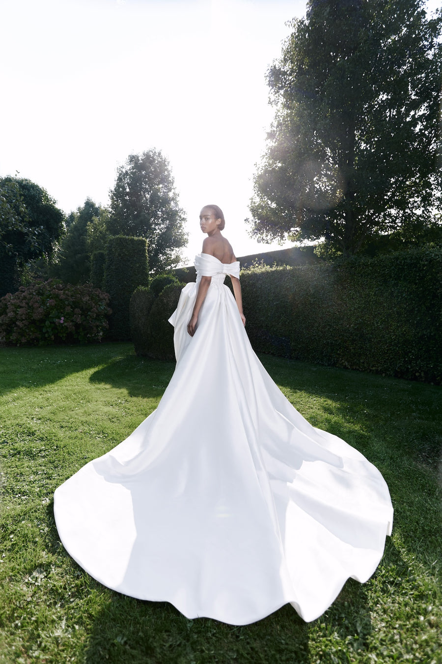 Viktor & Rolf Mariage Bridalwear Collection, Autumn Winter 25, elegant gown with off-shoulder design and flowing train.