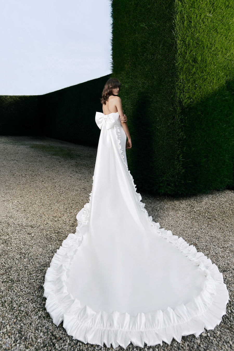 Viktor & Rolf Mariage Bridalwear Collection, elegant white gown with dramatic bow and flowing ruffled train, Autumn Winter 25.
