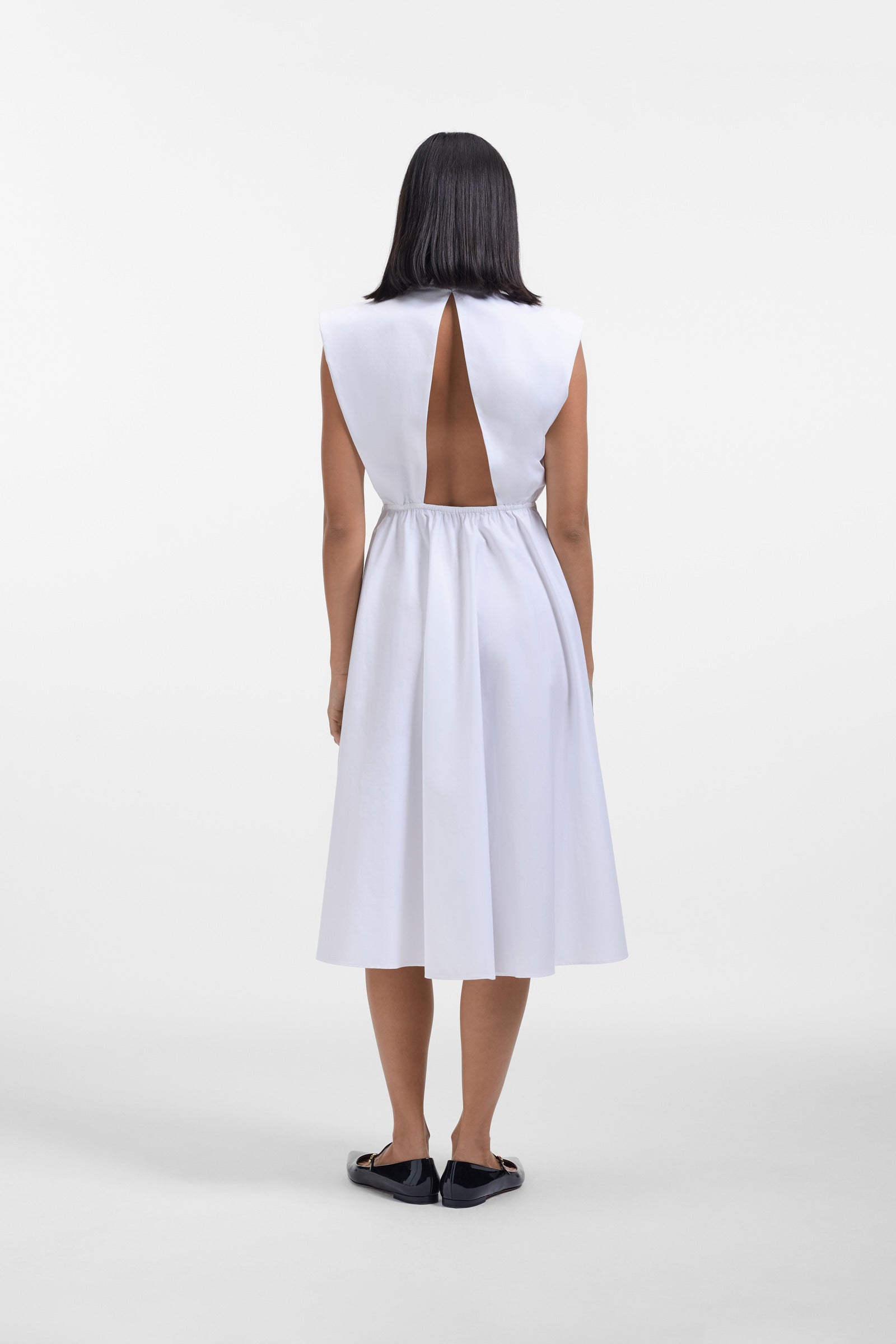 Model wearing a white shirt dress with a multi-layer collar on a withe background.