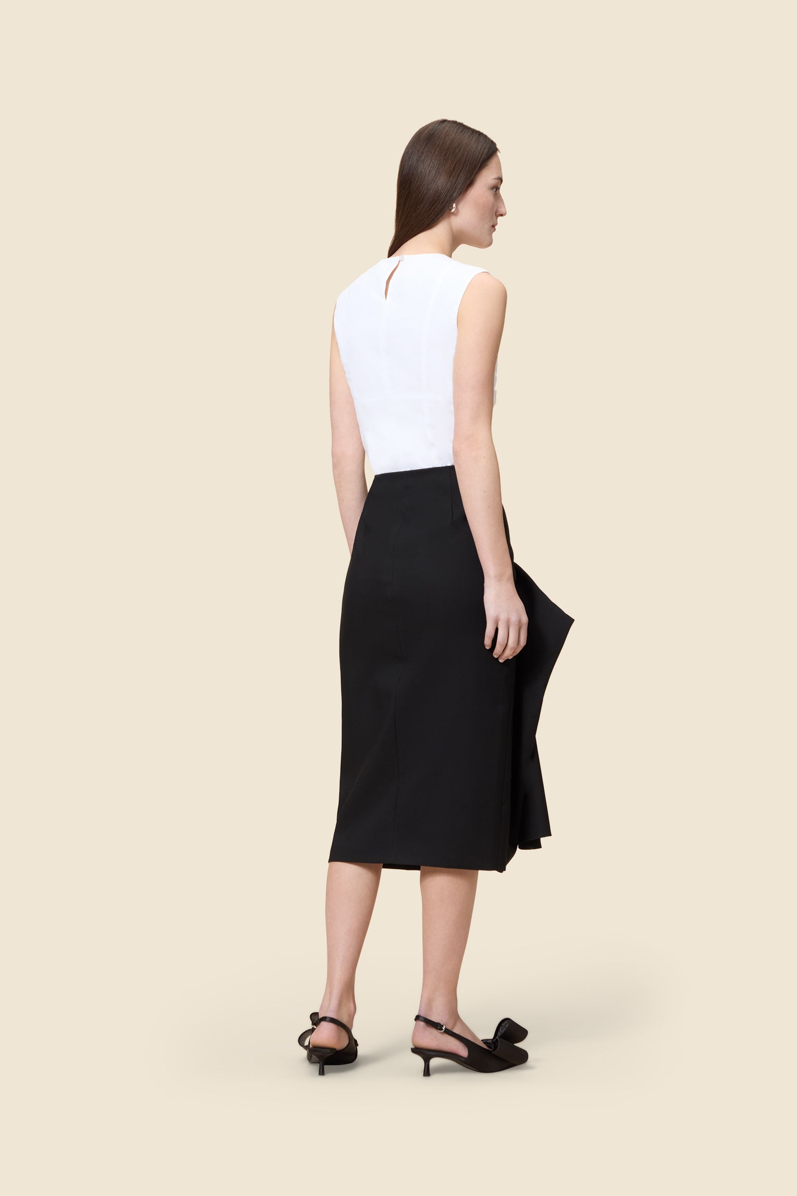 The craftmanship of the skirt reinterprets classic haute couture tuck ups into a modern silhouette from wool