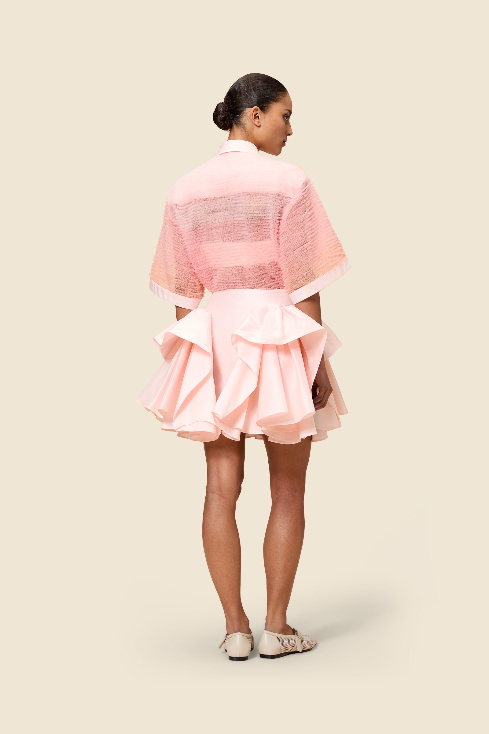 The craftmanship of the skirt reinterprets classic haute couture tuck ups into a modern silhouette from silk-blend taffeta