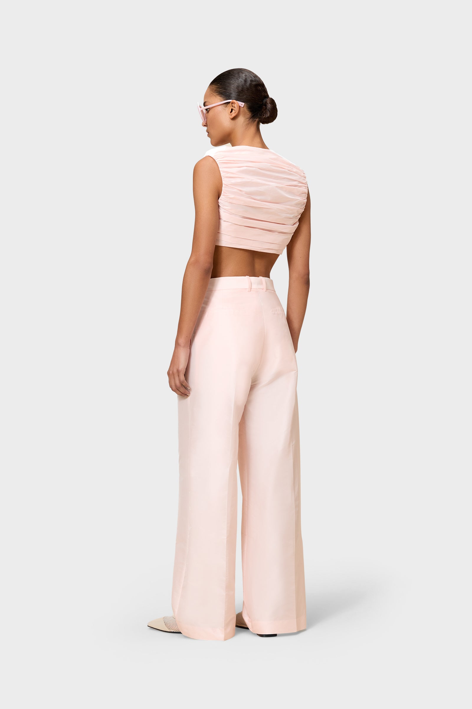 Model wearing a pink satin set on a white background.