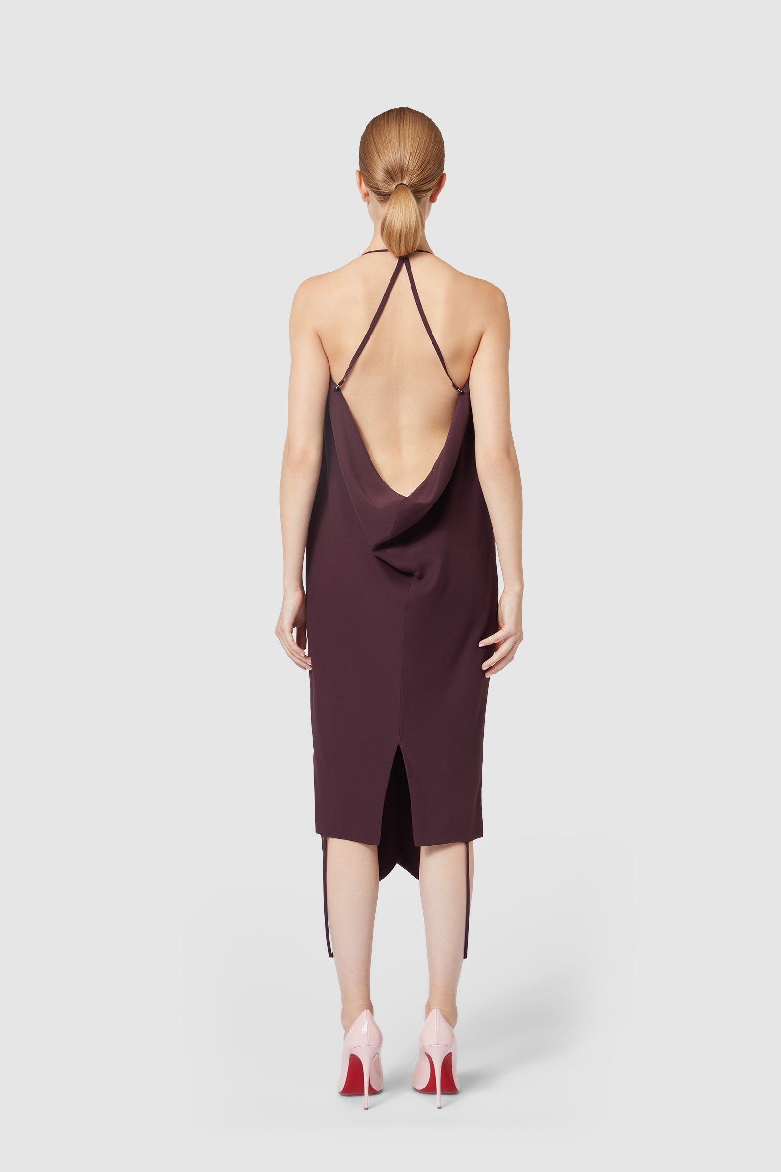 Backless plum midi dress with a draped cowl accent, featuring delicate spaghetti straps, creating an elegant evening silhouette.