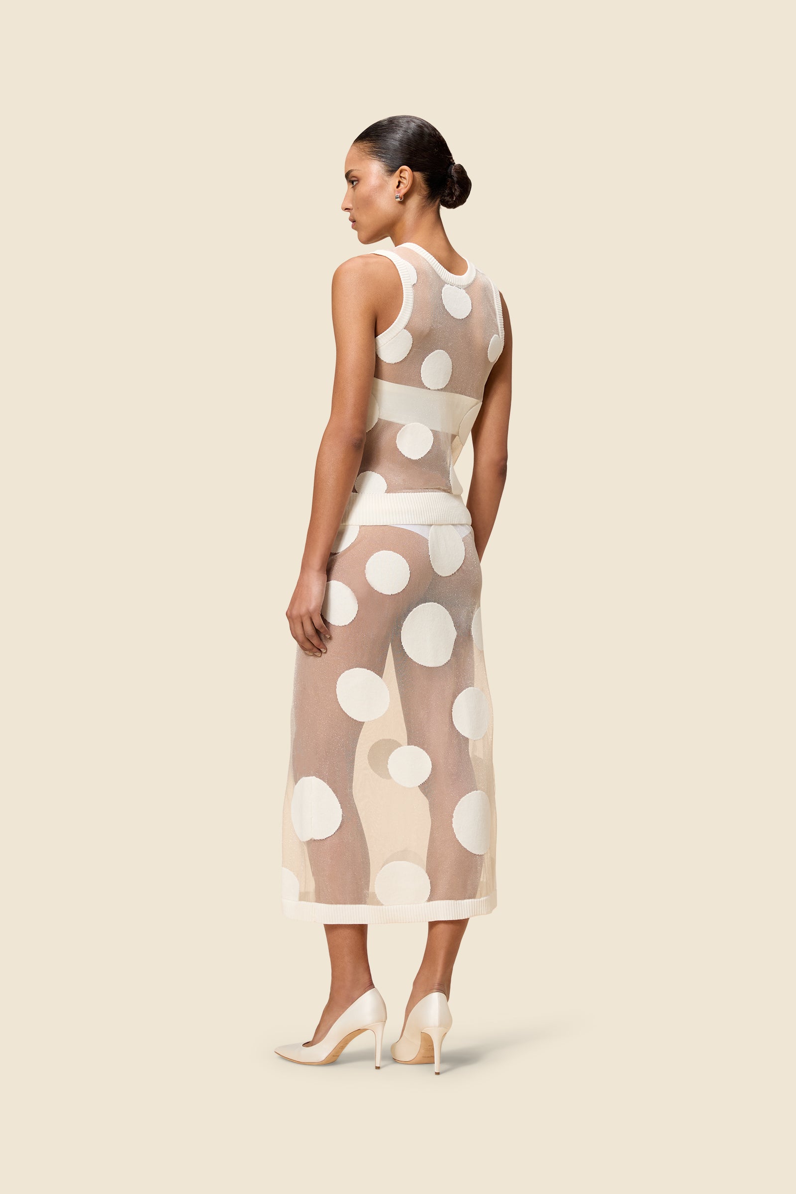 The classic pattern of the skirt is given a modern twist with intricate polka dot hole design on knit jacquard