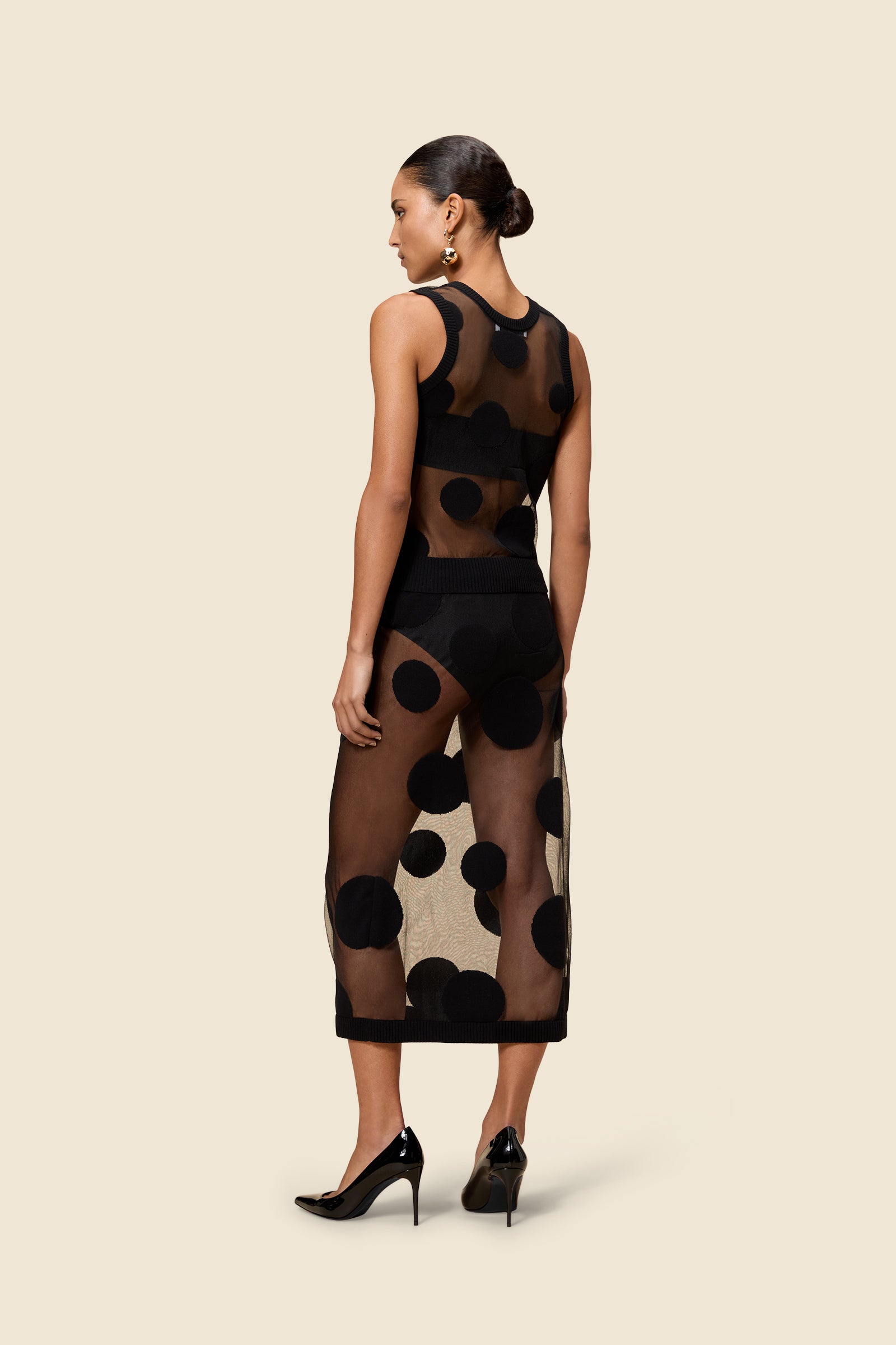The classic pattern of the skirt is given a modern twist with intricate polka dot hole design on knit jacquard