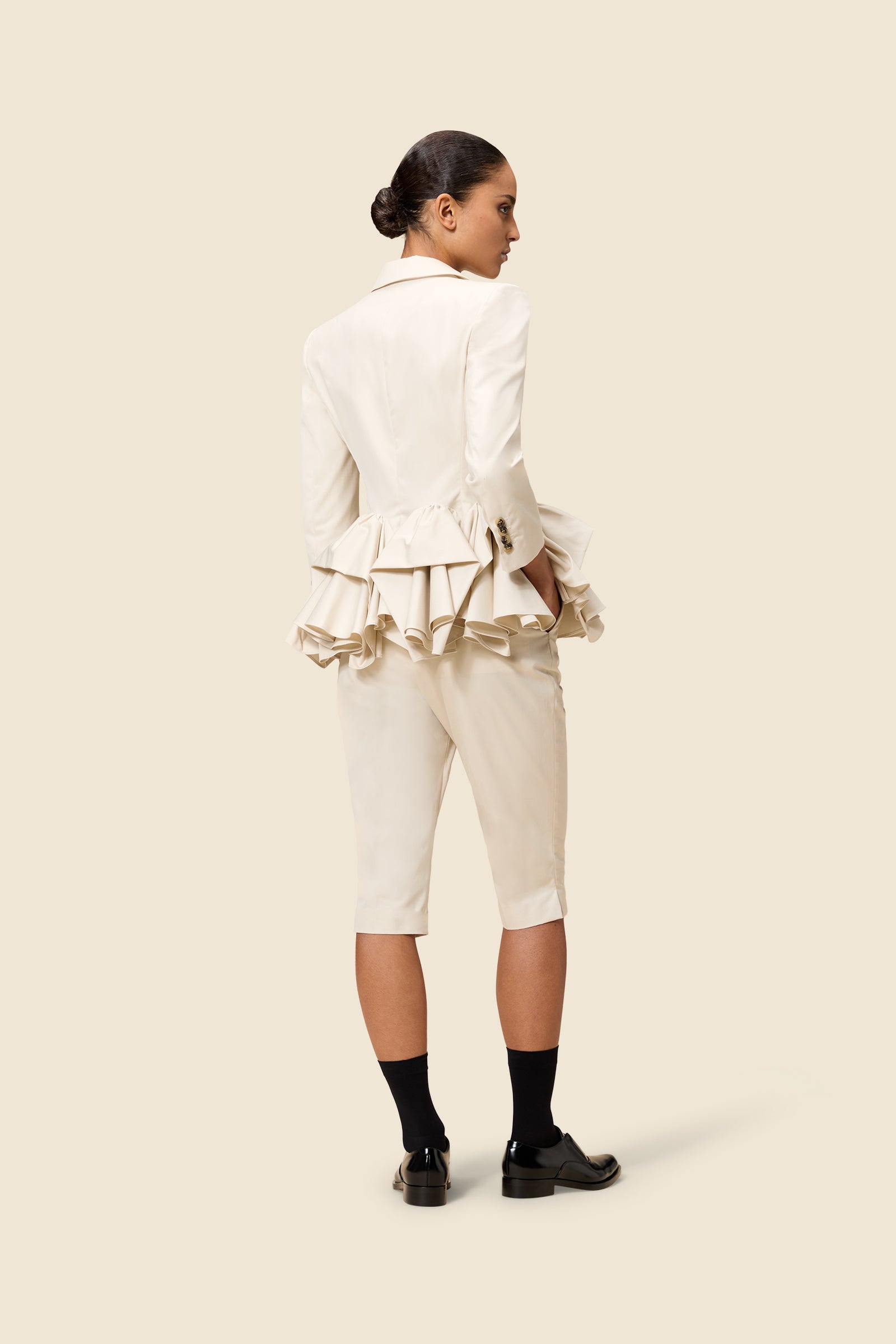 The craftmanship of the blazer reinterprets classic haute couture tuck ups into a modern silhouette from gabardine