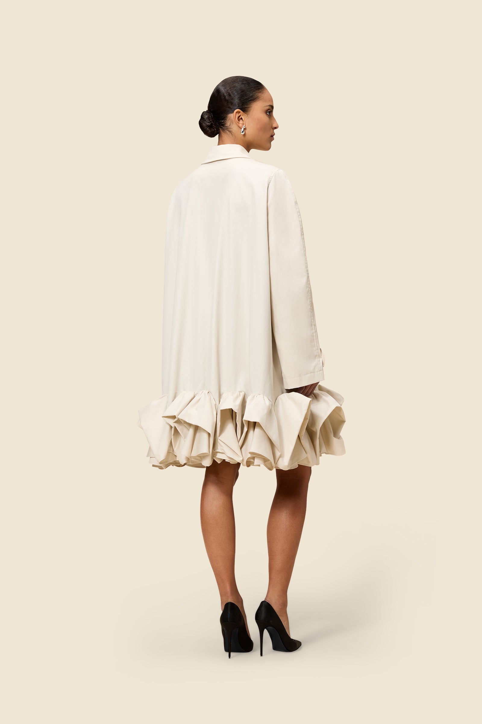 The craftmanship of the trenchcoat reinterprets classic haute couture tuck ups into a modern silhouette from gabardine
