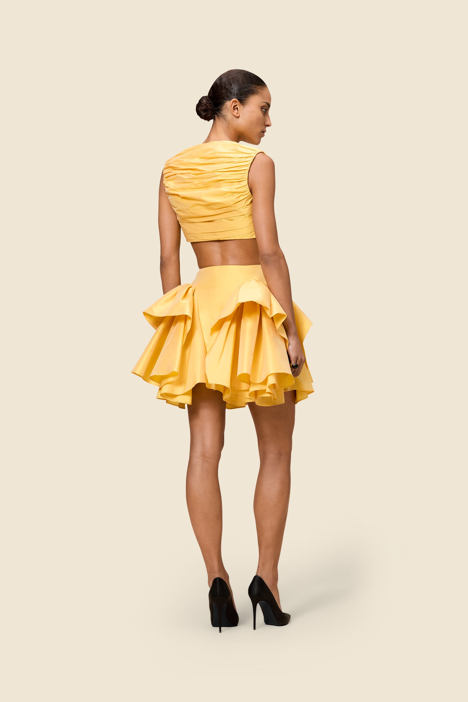 The meticulously placed pleats and silk-blend taffeta define the elegance of the top, reflecting classic haute couture craftsmanship with a modern edge