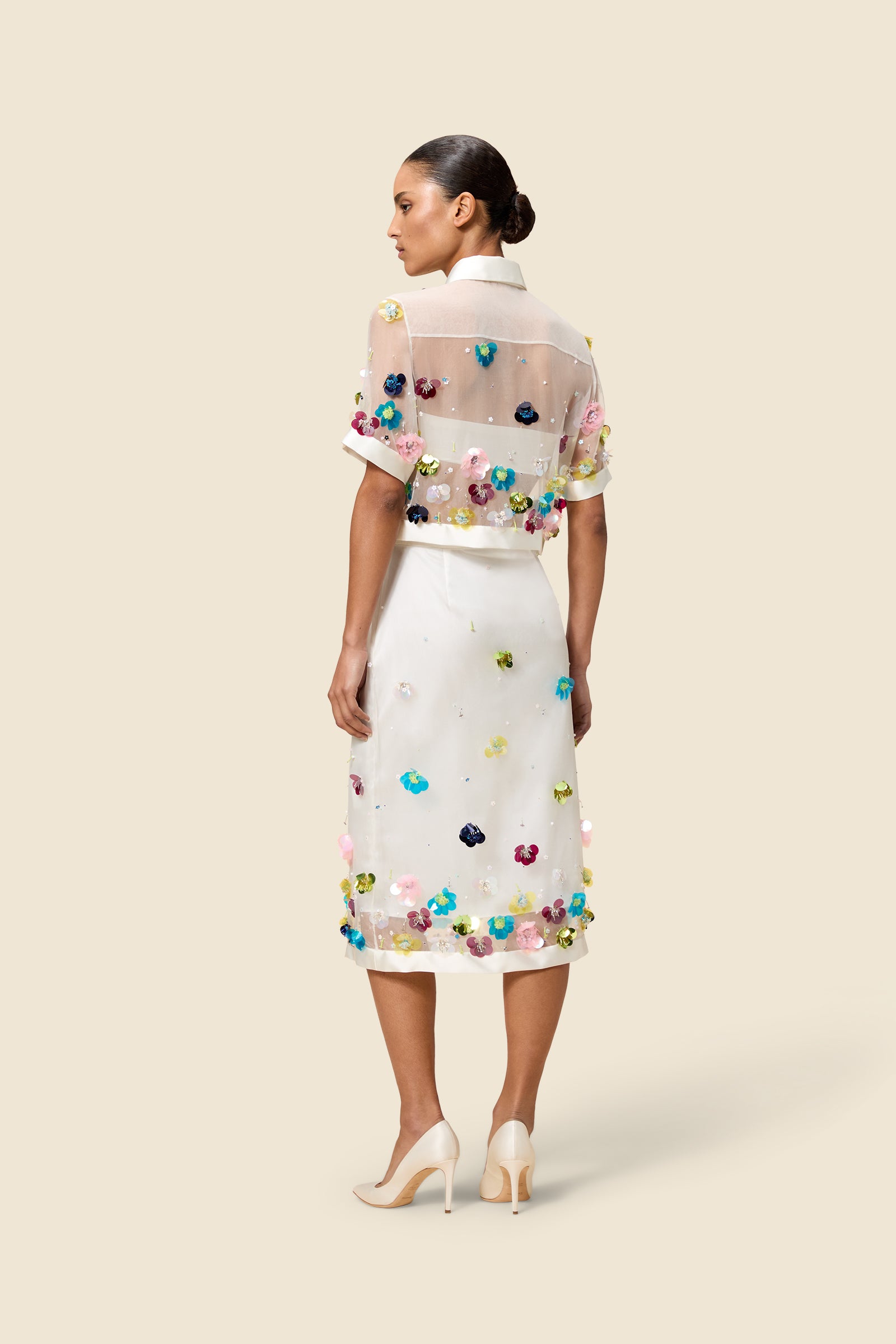 With hand-applied paillettes and crystals on silk organza featuring the satin edges, the skirt transforms classic floral embroidery into a modern piece