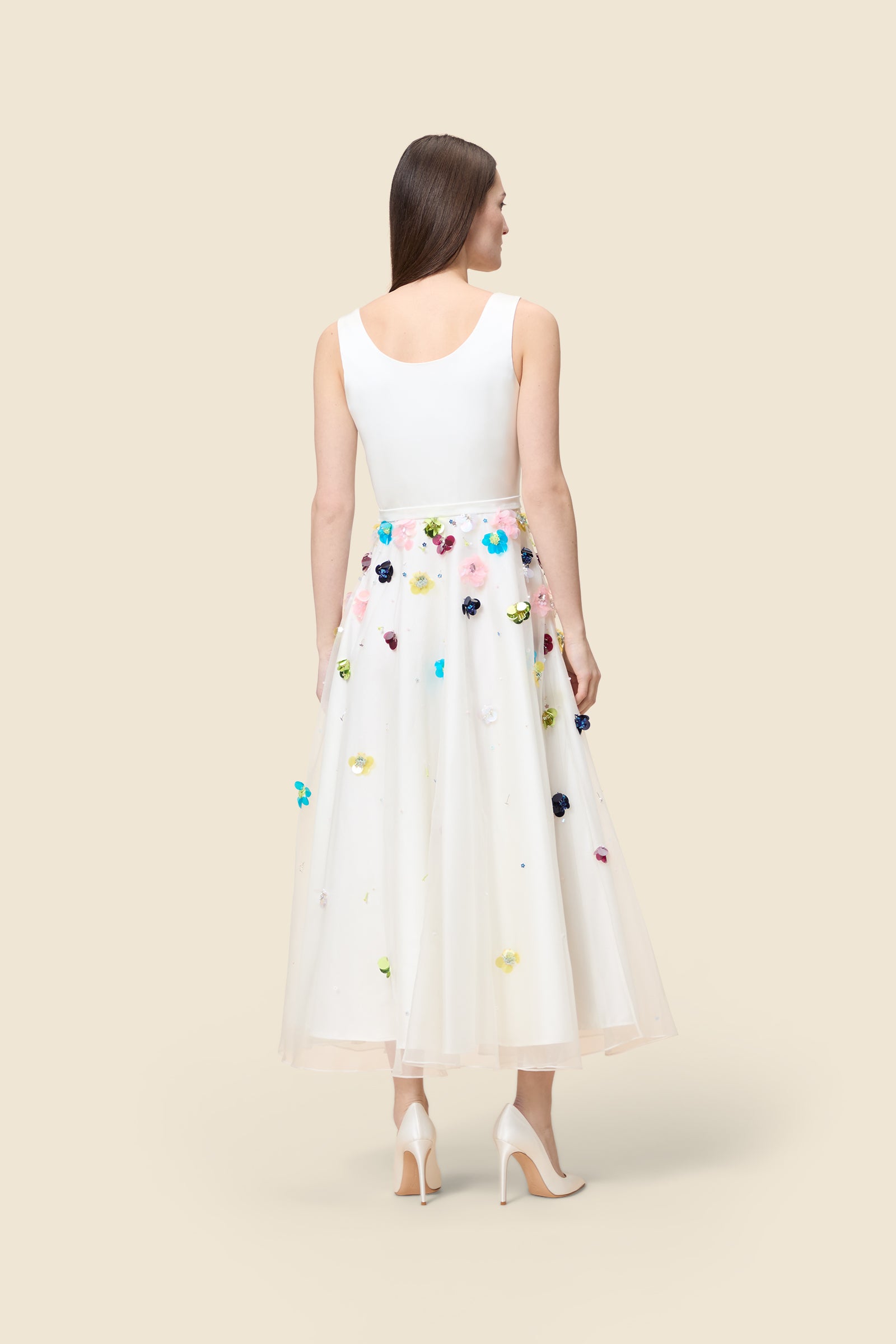 With hand-applied paillettes and crystals on silk organza featuring the satin edges, the dress transforms classic floral embroidery into a modern piece