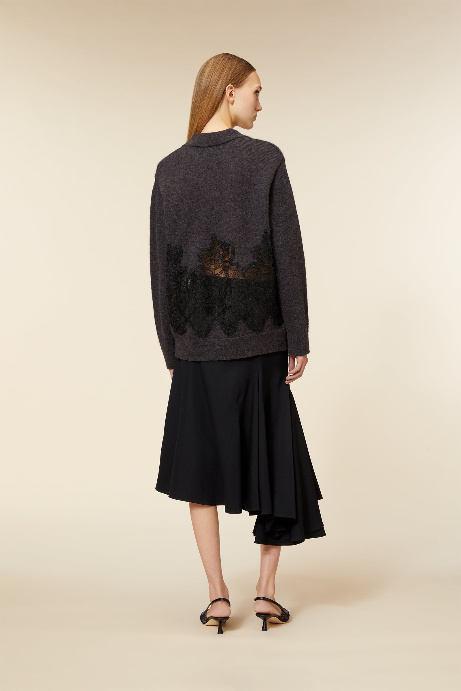 Gray wool sweater featuring intricate black lace floral embroidery, paired with an asymmetrical black midi skirt.
