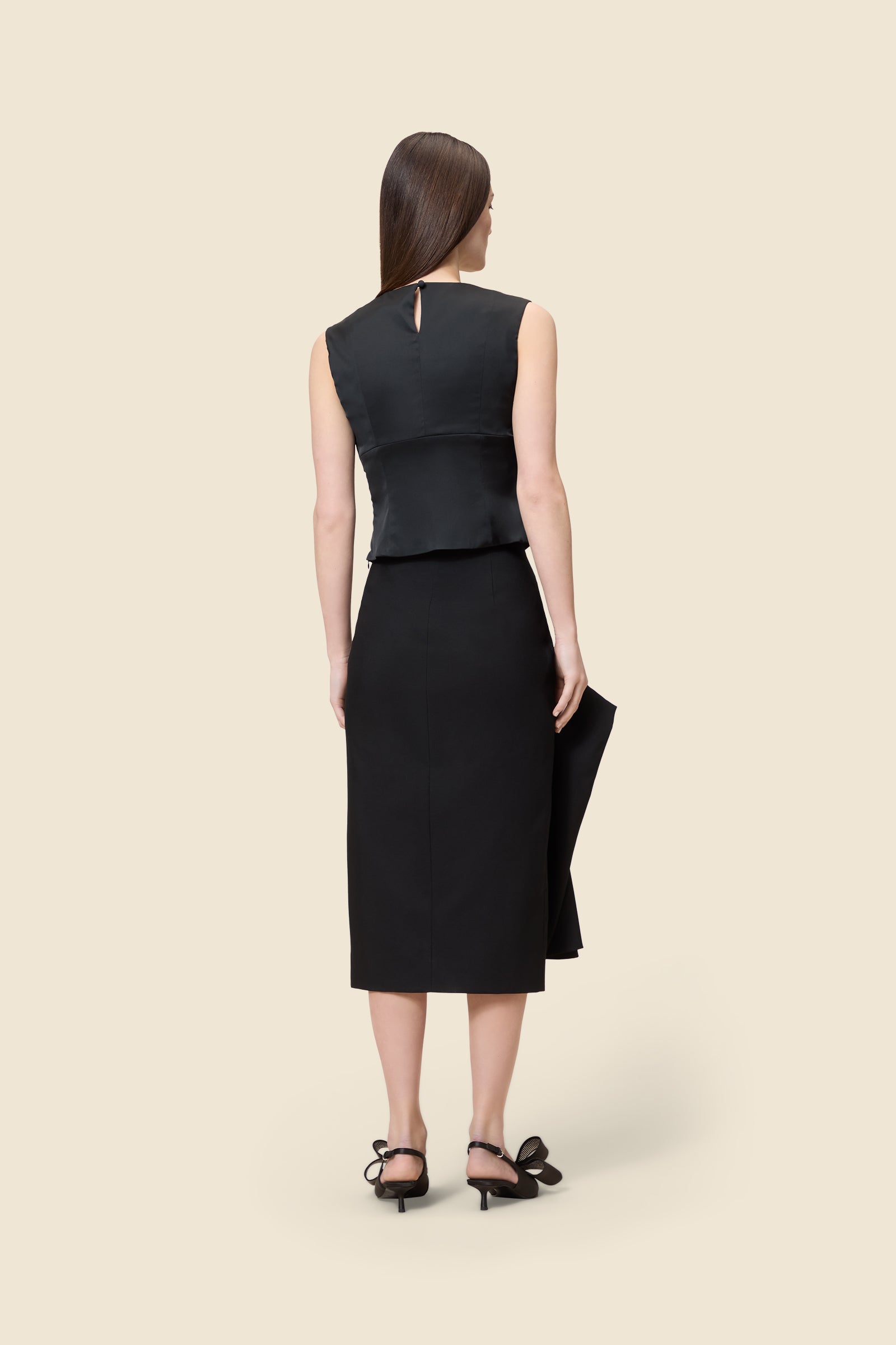 The meticulously placed pleats and stretch satin define the elegance of the top, reflecting classic haute couture craftsmanship with a modern edge