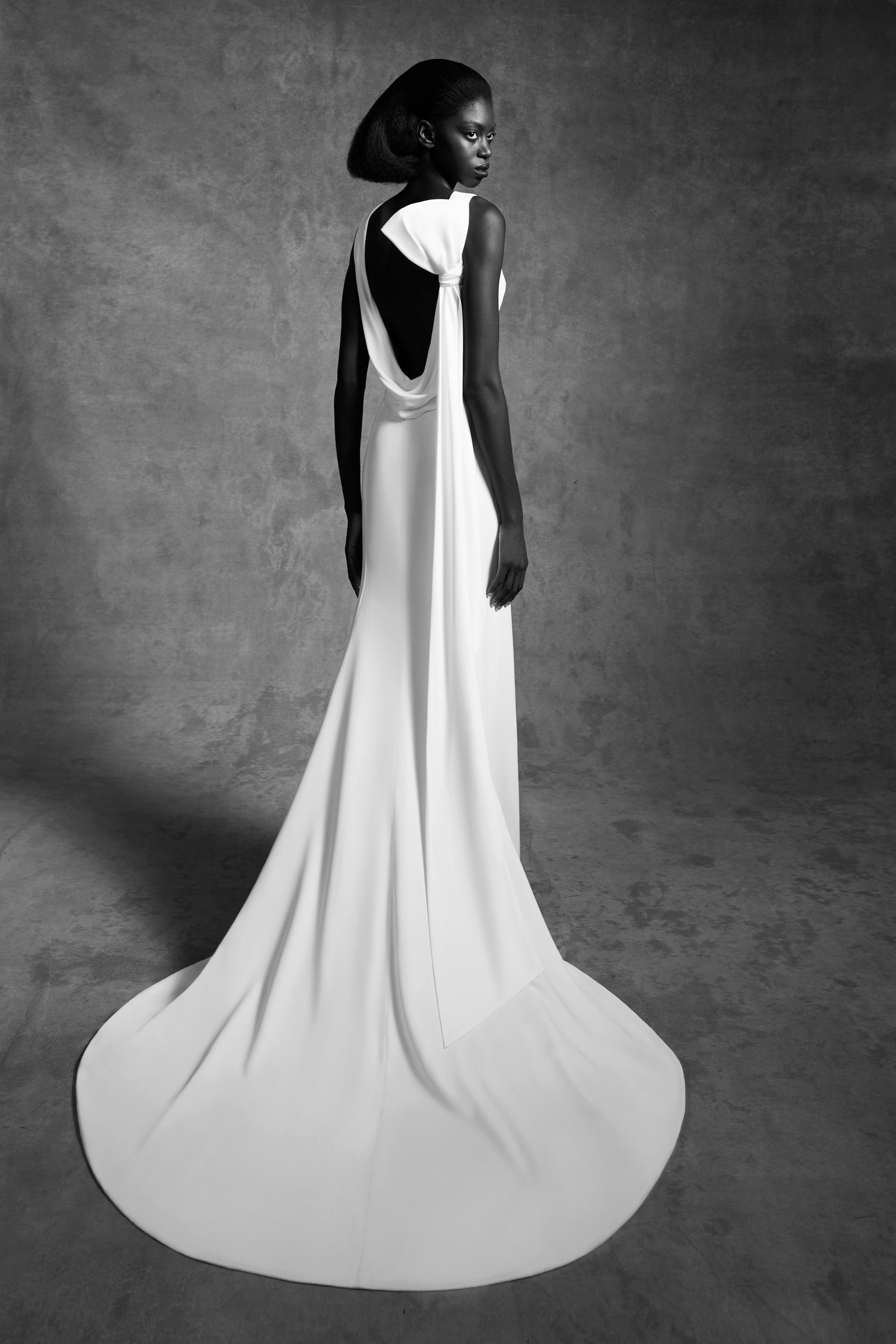 Column gown with a statement draped open back and a signature viktor&rolf tilted bow that leads way to an elegant train