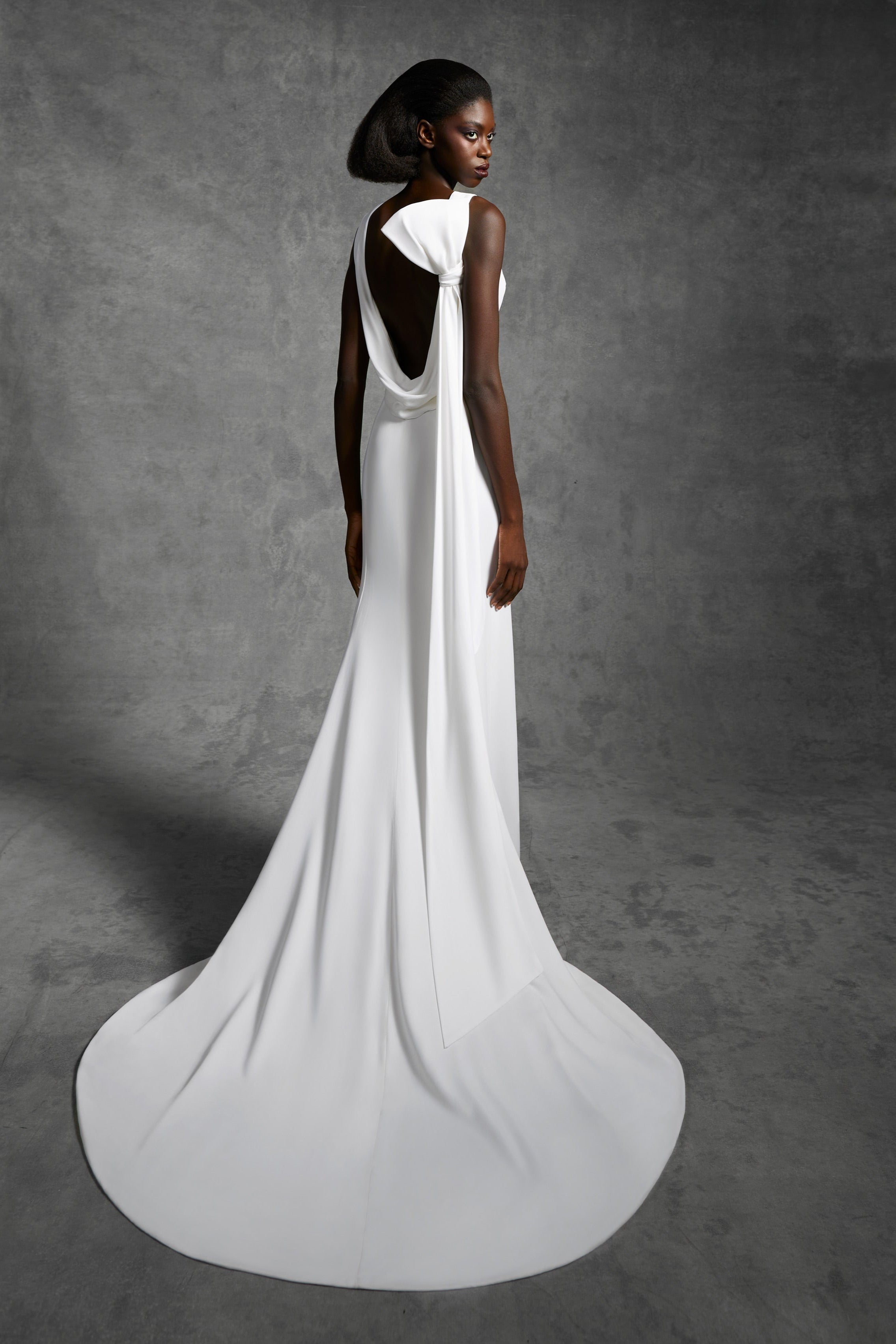Column gown with a statement draped open back and a signature viktor&rolf tilted bow that leads way to an elegant train