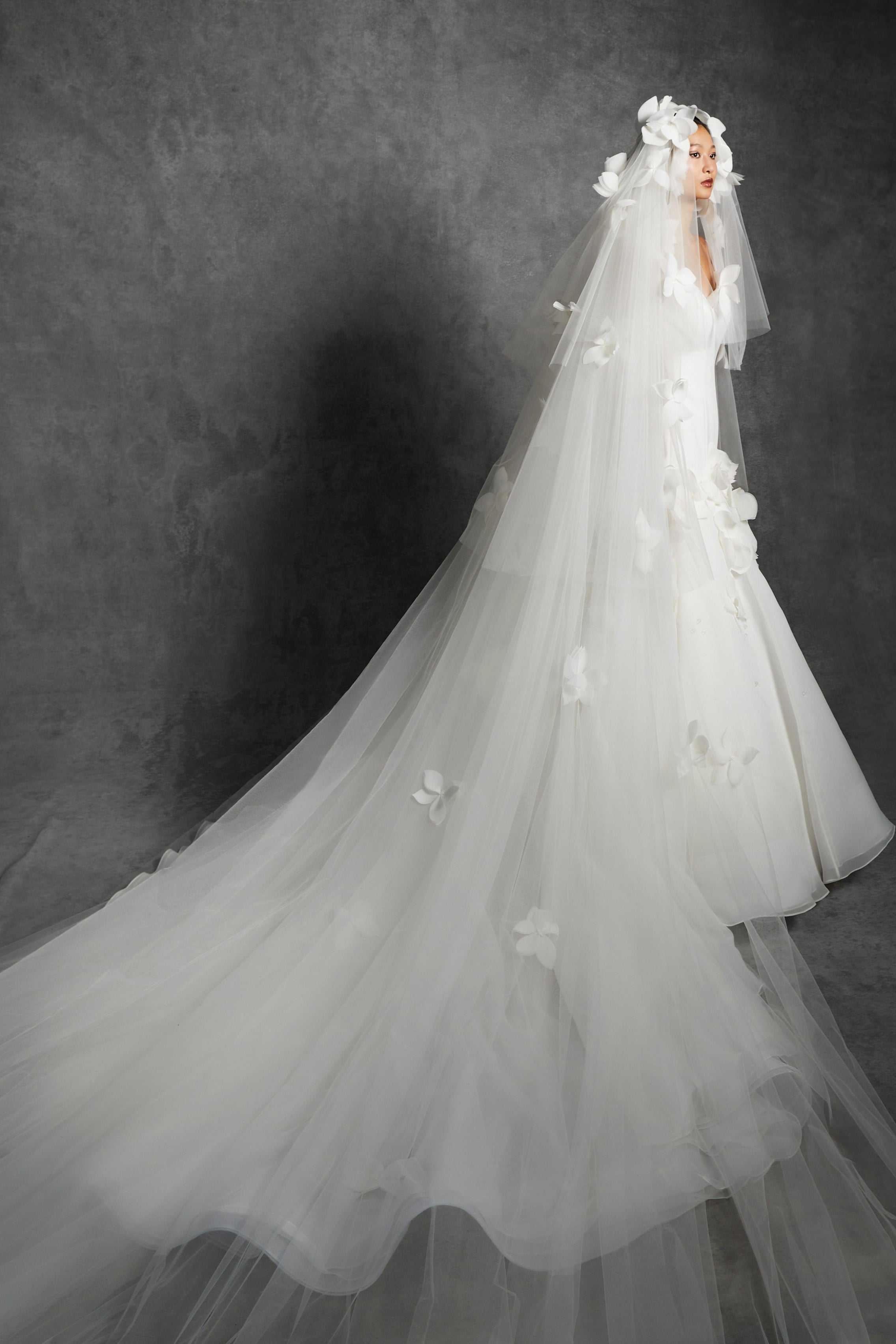 Tulle veil adorned with feathered airy organza flowers cascading down the sheer veil