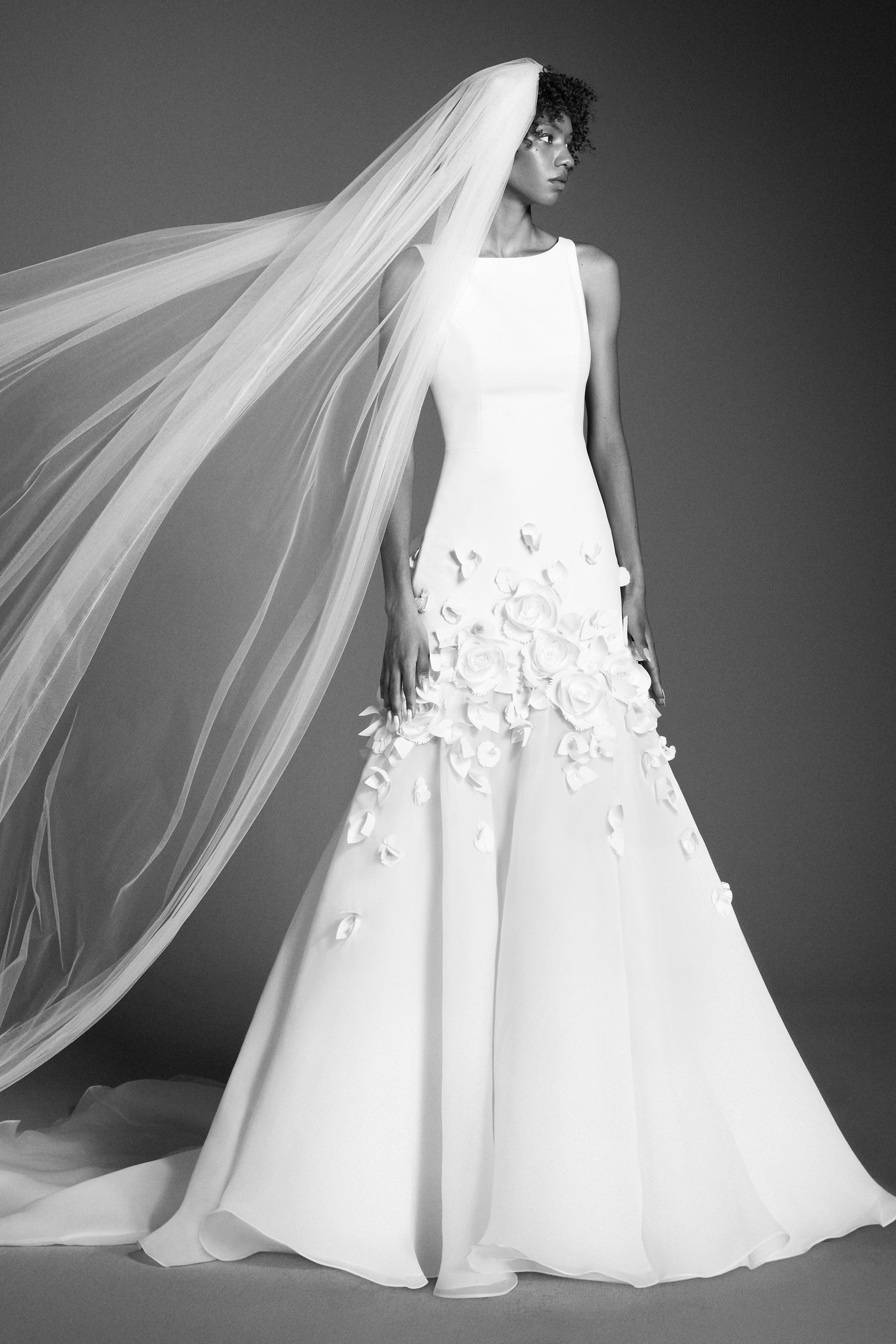 This refined mermaid gown, crafted from crepe with a slight stretch, perfectly molds to the wearer’s body before flaring out into a decadent train