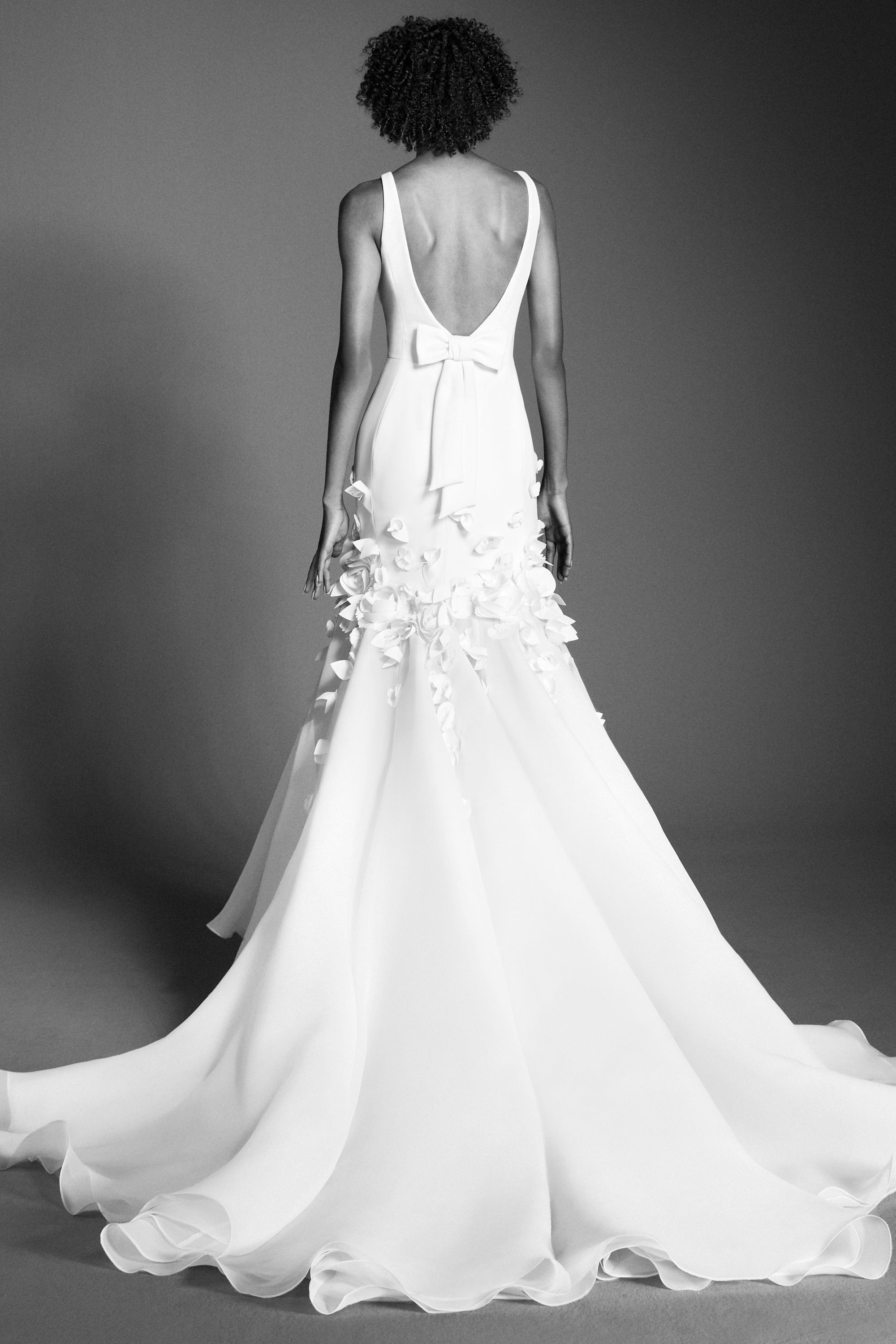 This refined mermaid gown, crafted from crepe with a slight stretch, perfectly molds to the wearer’s body before flaring out into a decadent train