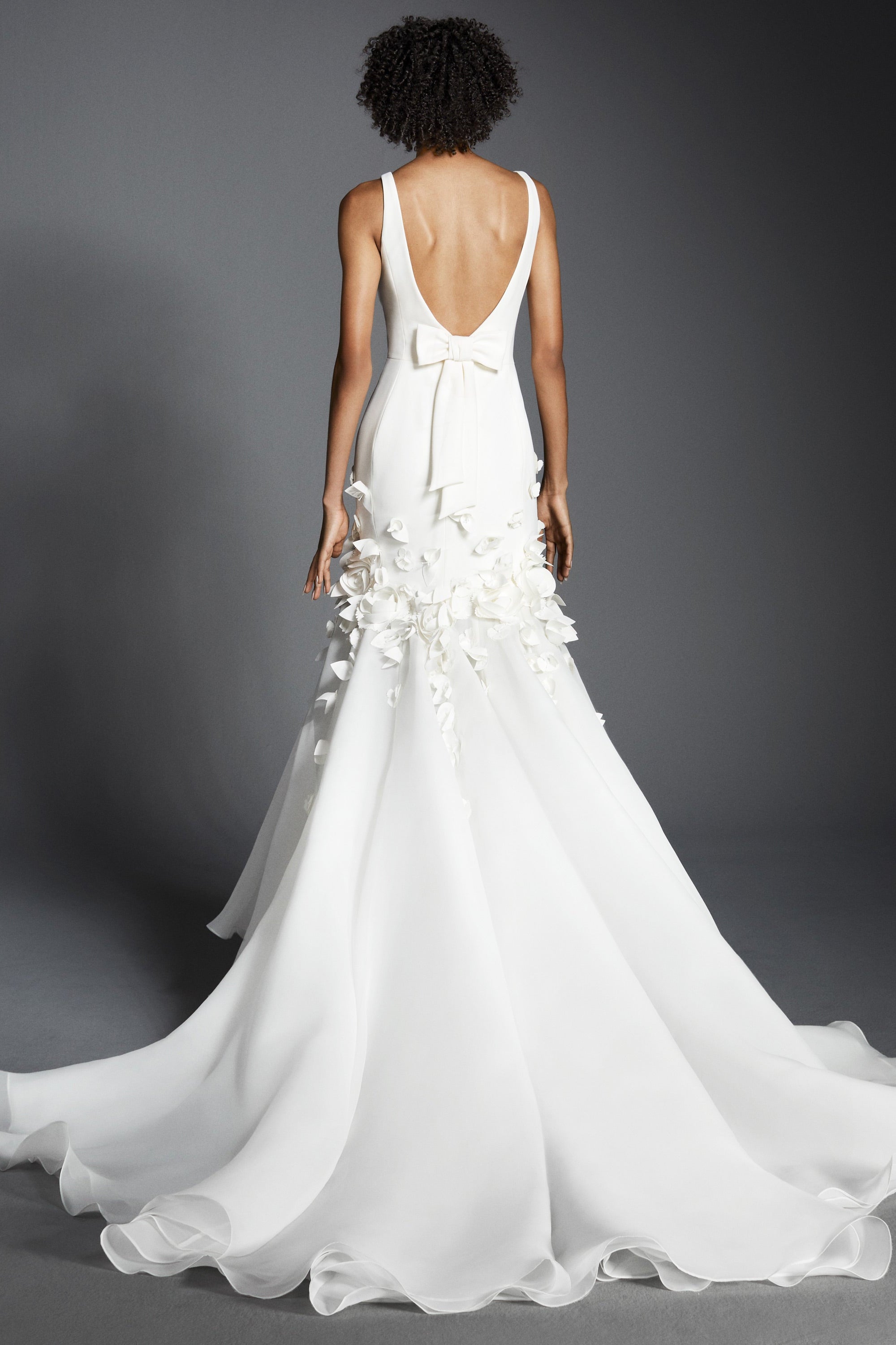 This refined mermaid gown, crafted from crepe with a slight stretch, perfectly molds to the wearer’s body before flaring out into a decadent train