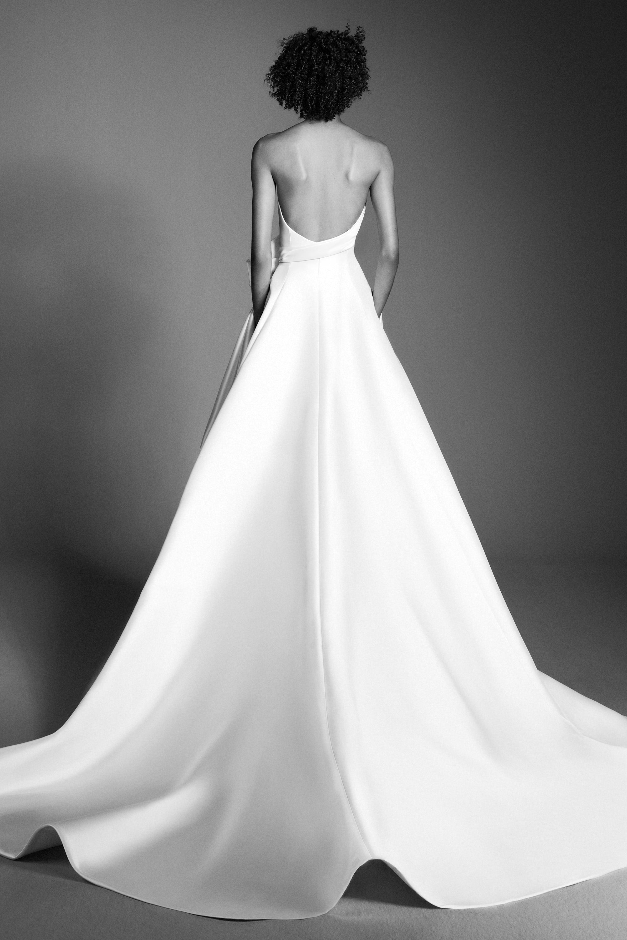 Crafted out of mikado, this gown features an intricately draped sweetheart bodice that leads way to a royal ribbon bow