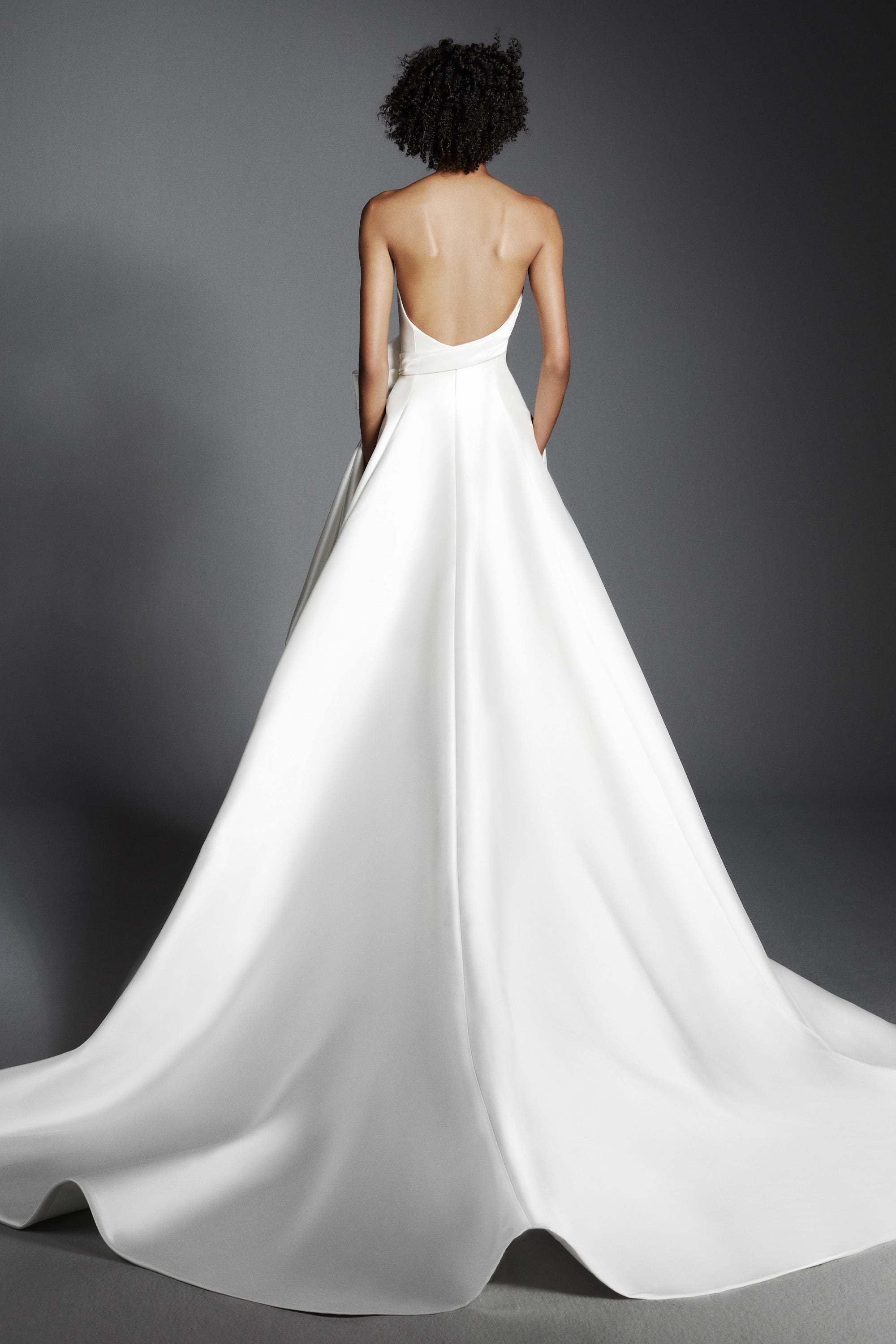 Crafted out of mikado, this gown features an intricately draped sweetheart bodice that leads way to a royal ribbon bow