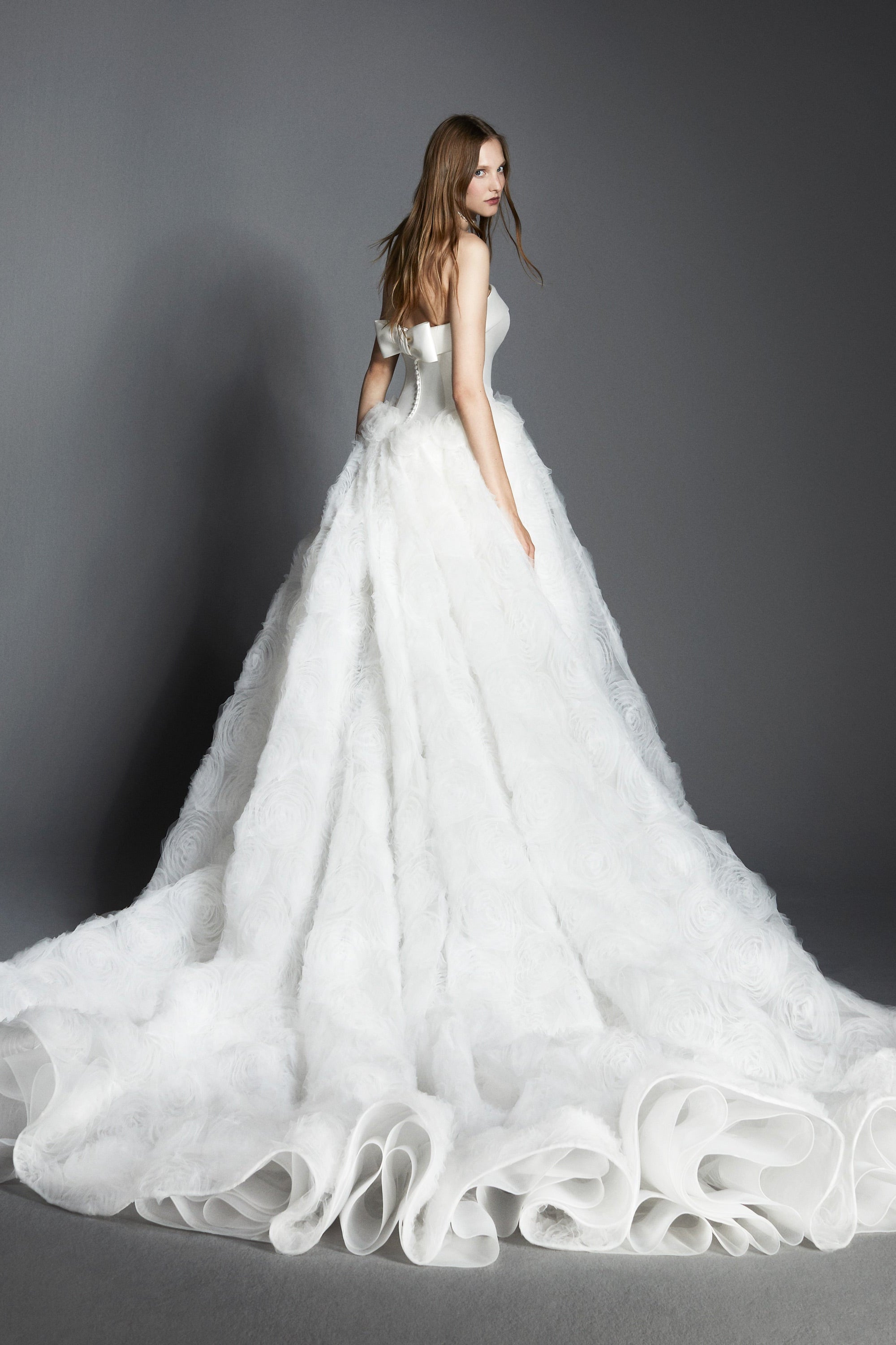 An elegant strapless ballgown featuring a mikado bodice paired with a tulle skirt adorned with textural tulle roses