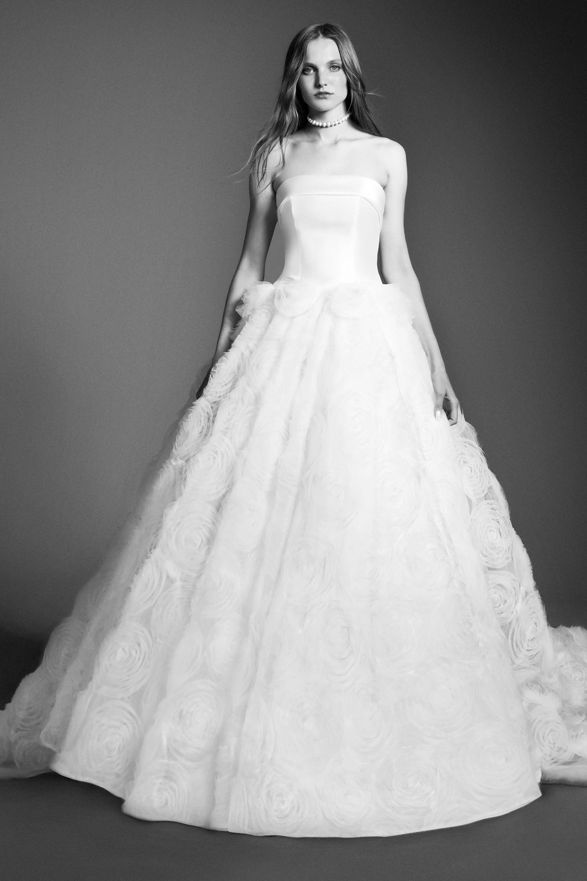 An elegant strapless ballgown featuring a mikado bodice paired with a tulle skirt adorned with textural tulle roses