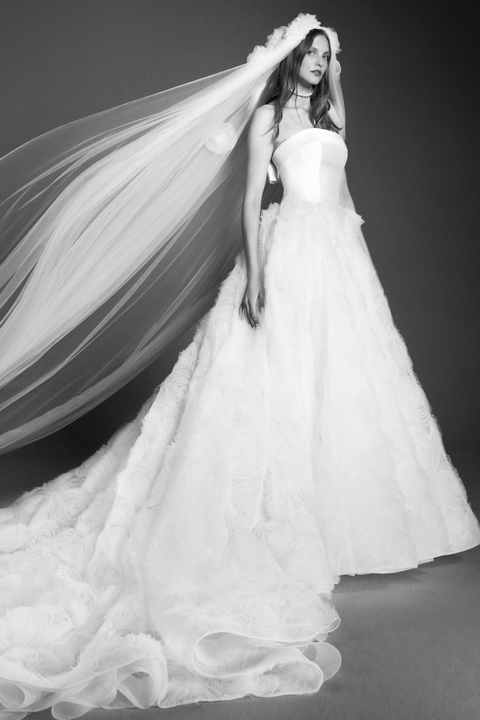 Delicate tulle roses gently descend along a dreamy and dramatic tulle veil