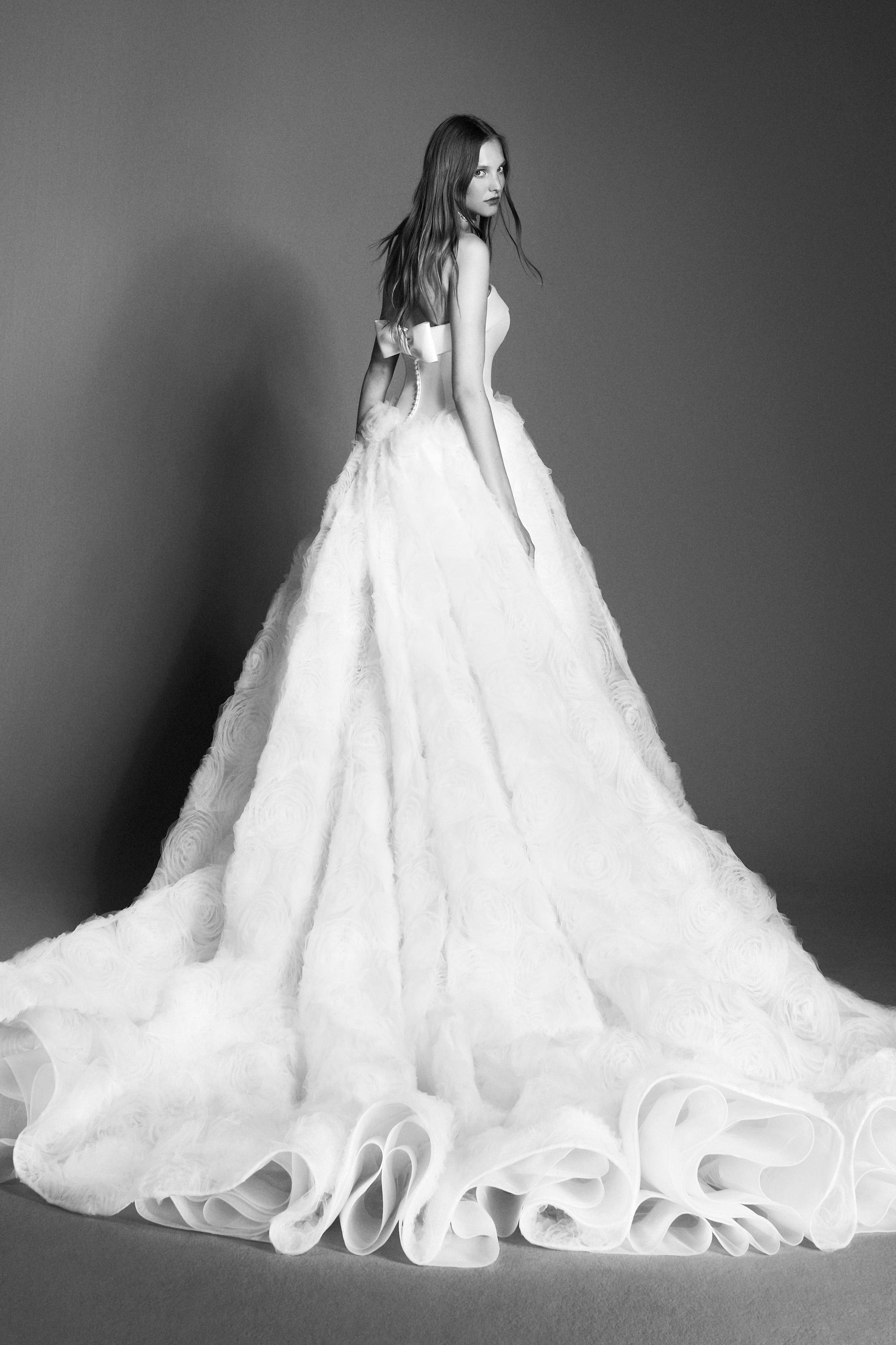 An elegant strapless ballgown featuring a mikado bodice paired with a tulle skirt adorned with textural tulle roses