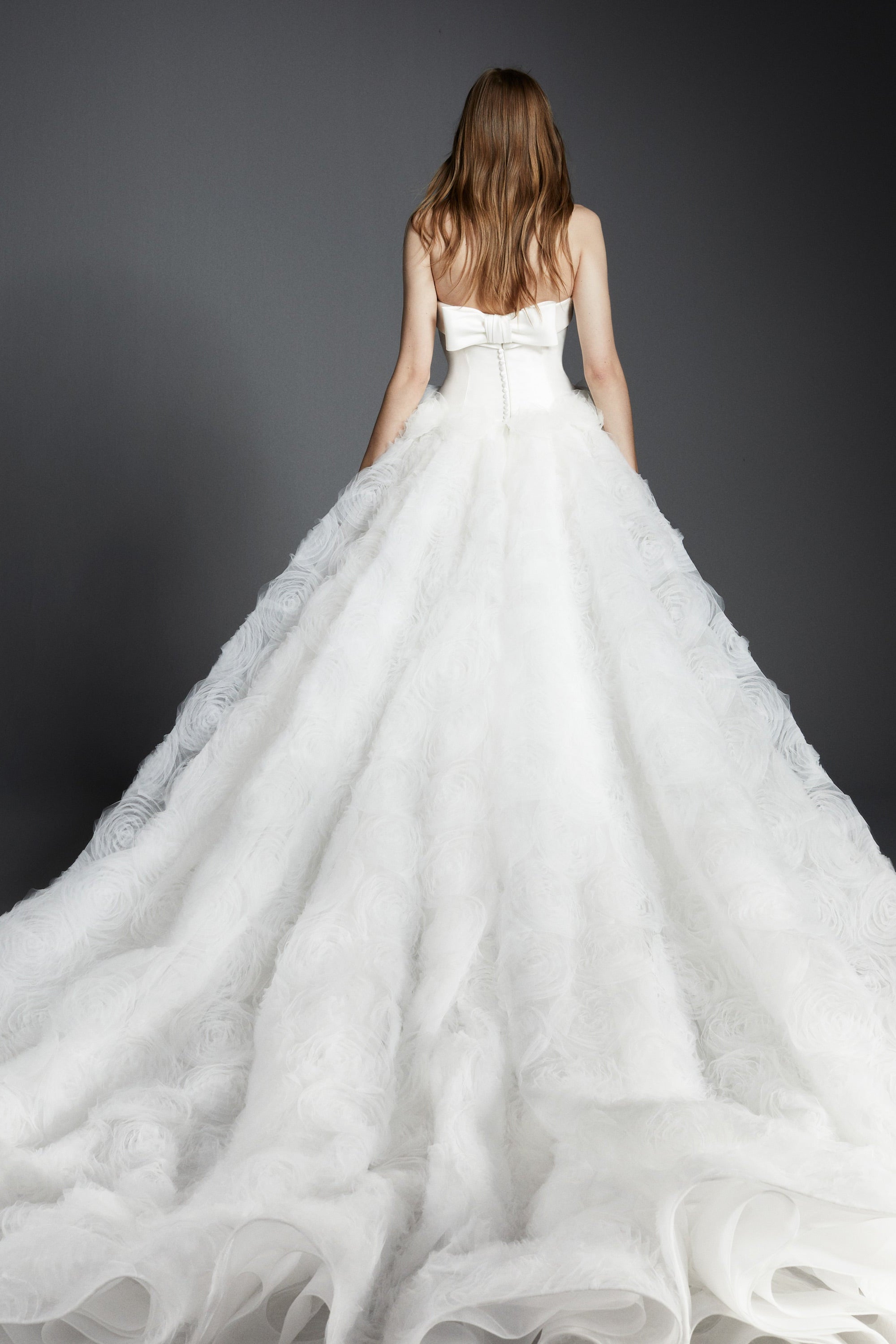 An elegant strapless ballgown featuring a mikado bodice paired with a tulle skirt adorned with textural tulle roses