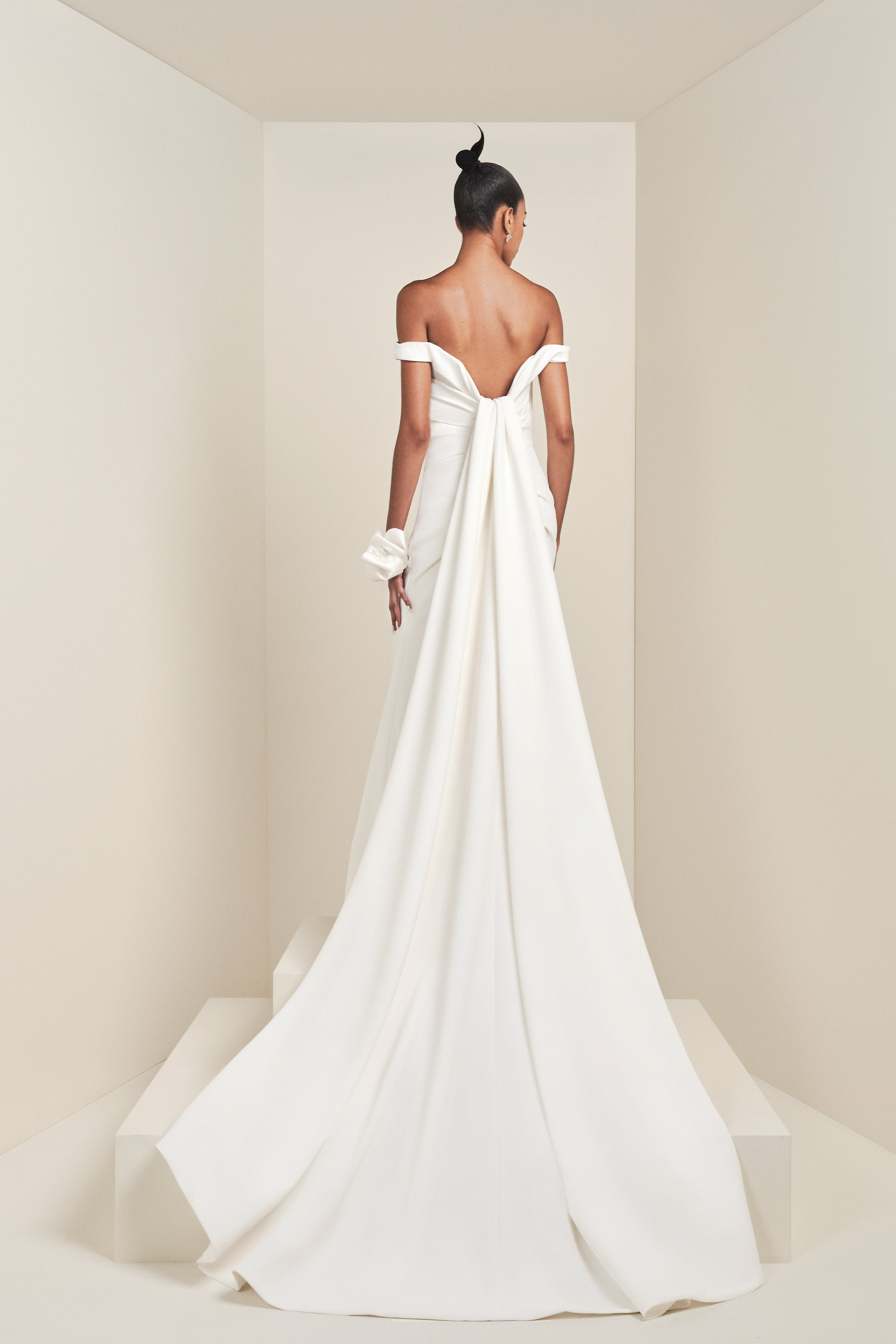 Crafted from crepe fabric with a slight stretch, this gown boasts a fitted bodice that transitions into a mermaid skirt