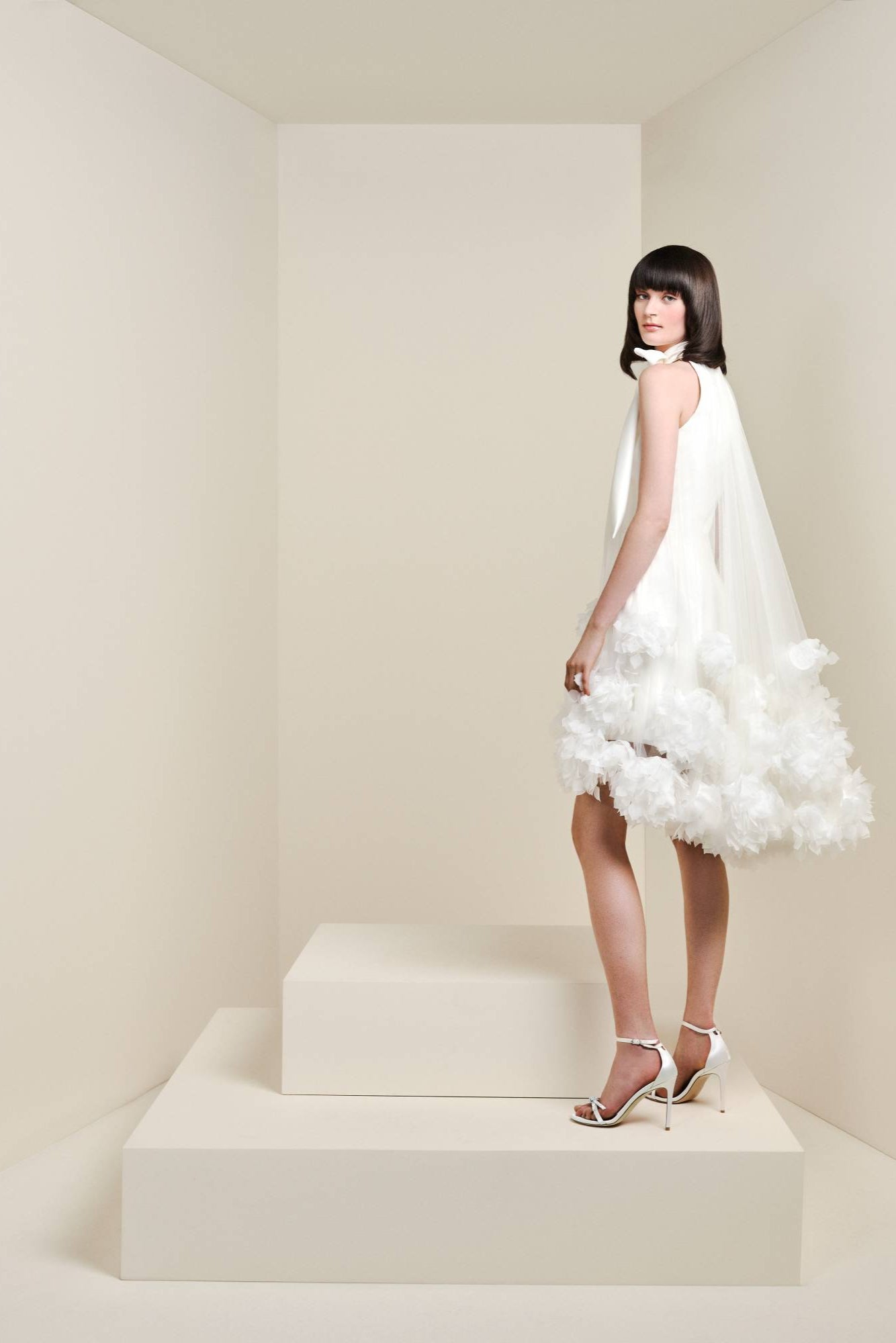 This short dress is crafted from matte satin fabric, overlaid with a romantic tulle sheath dress