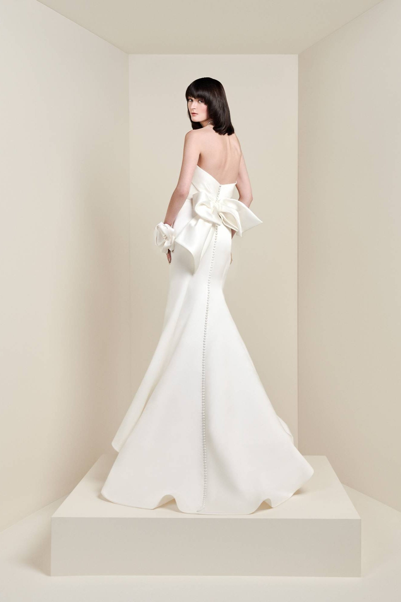 Crafted from satin fabric, this timeless gown features a modern draped strapless bodice with a fitting built-in corset