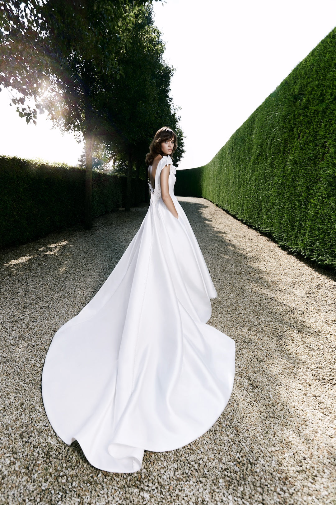 Viktor & Rolf Mariage Bridalwear Collection Intricate Florals gown, elegant A-line with flowing train in outdoor setting.