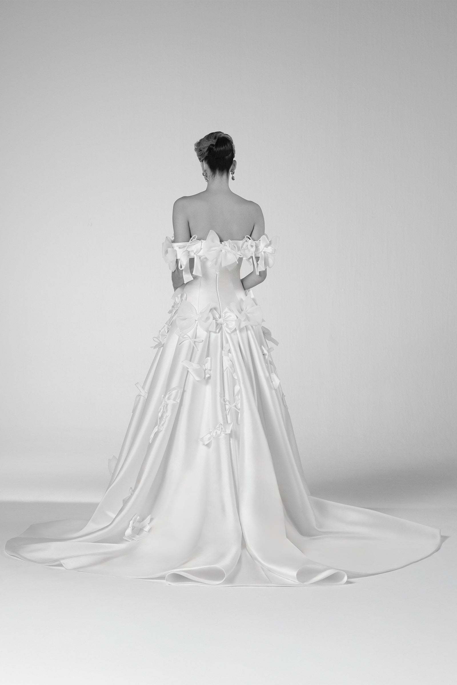 Crafted in mikado, the gown features an abundant couture bow embellishment, adorning the voluminous skirt and detachable bolero and elegantly highlighting the dropped waistline and clean bustier, from the Viktor&Rolf Mariage collection.