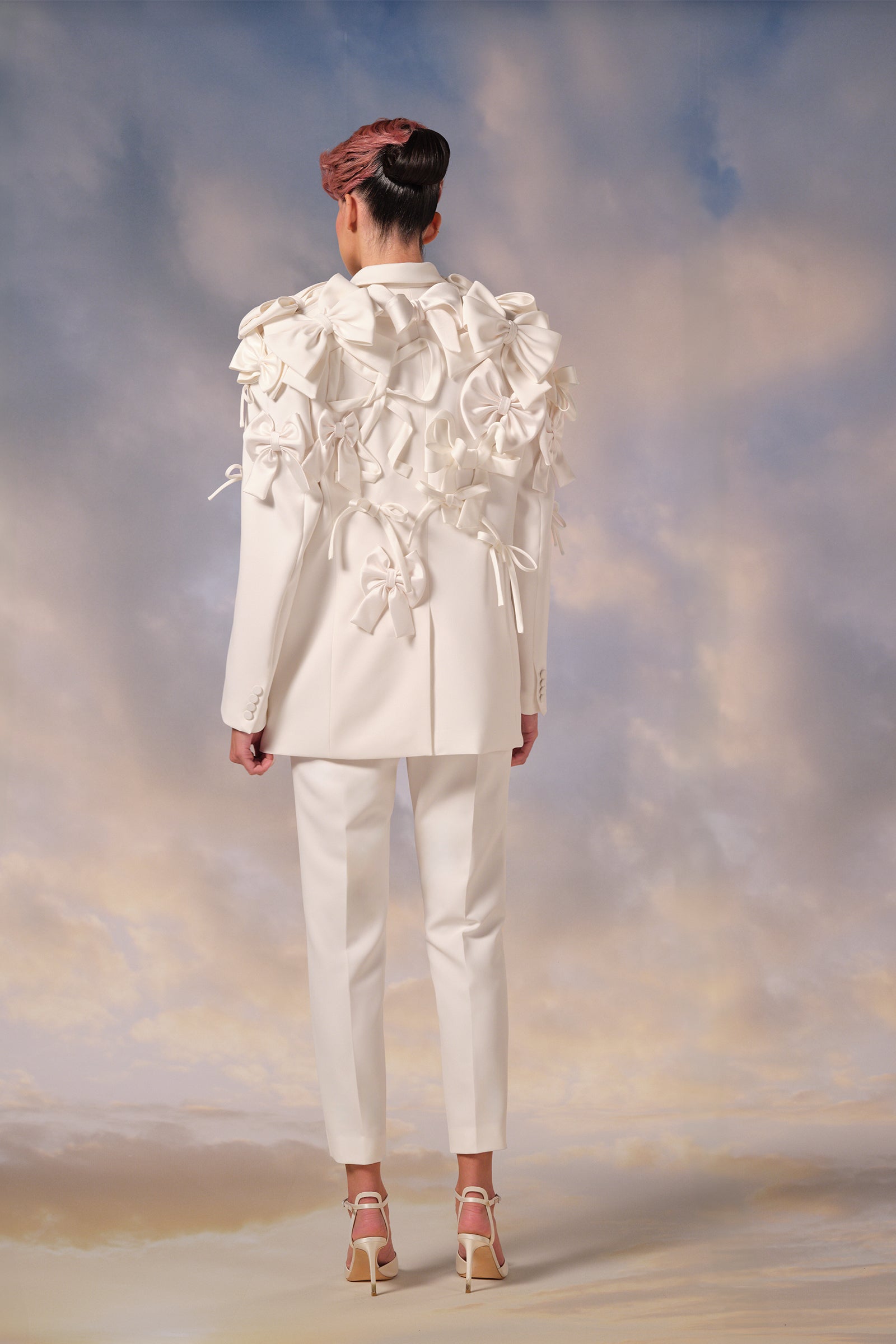 This tailored stretch crepe suit features a jacket with satin lapels forming an elegant v-neckline, paired with modern cigarette pants, from the Viktor&Rolf Mariage collection.