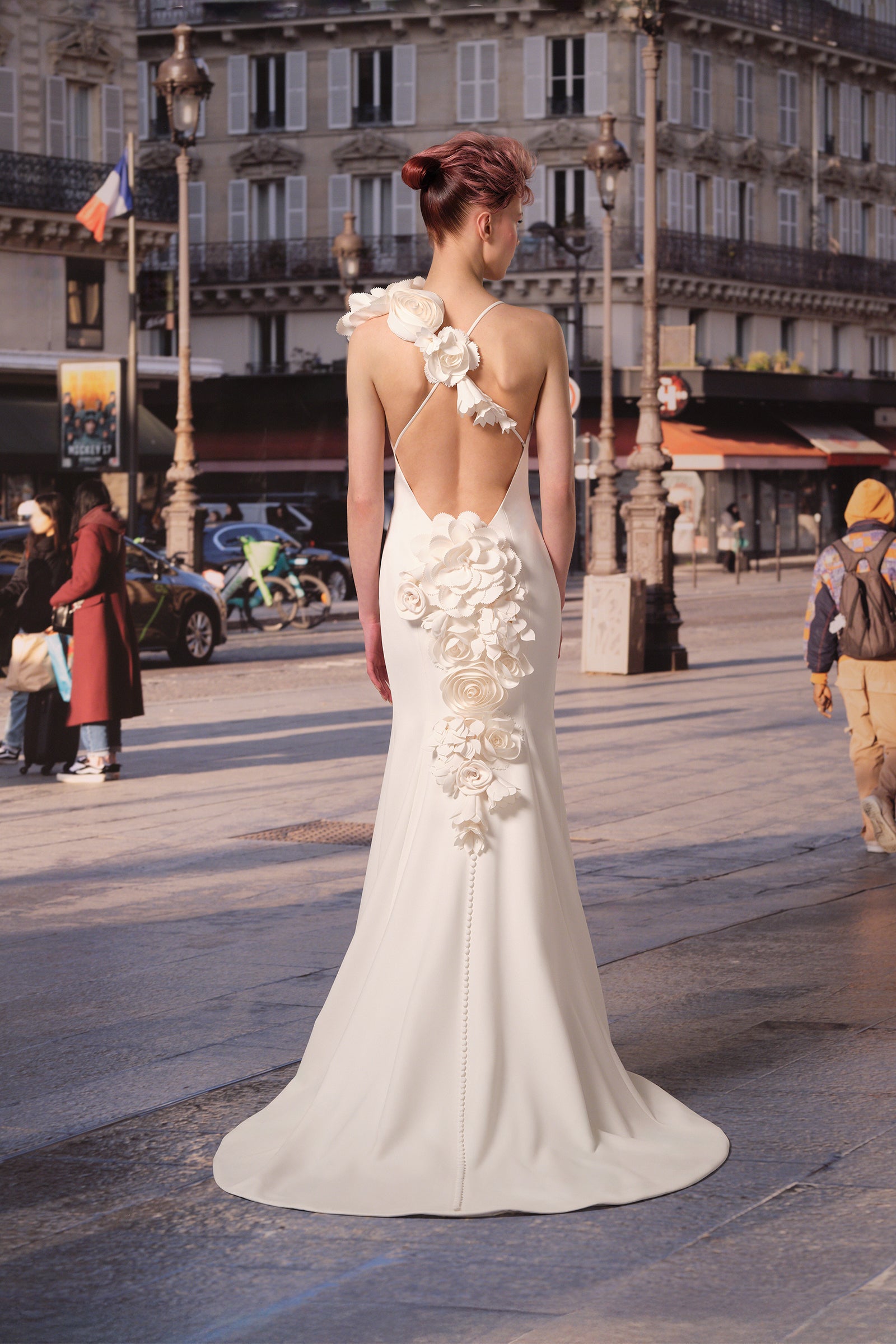 This stretch crepe mermaid gown features a striking plunging v-neck and open cross back adorned with delicate, handcrafted floral arrangements, from the Viktor&Rolf Mariage collection.
