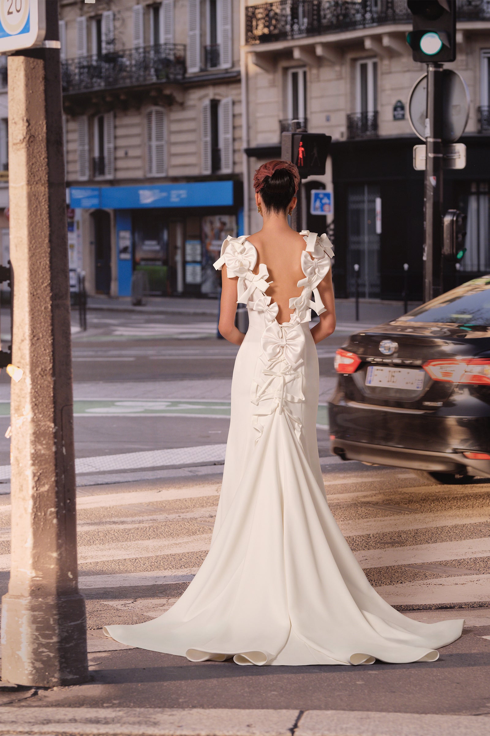 This refined mermaid gown in stretch crepe is adorned with a cascade of couture bows, framing the open sabrina neckline and plunging back, from the Viktor&Rolf Mariage collection.