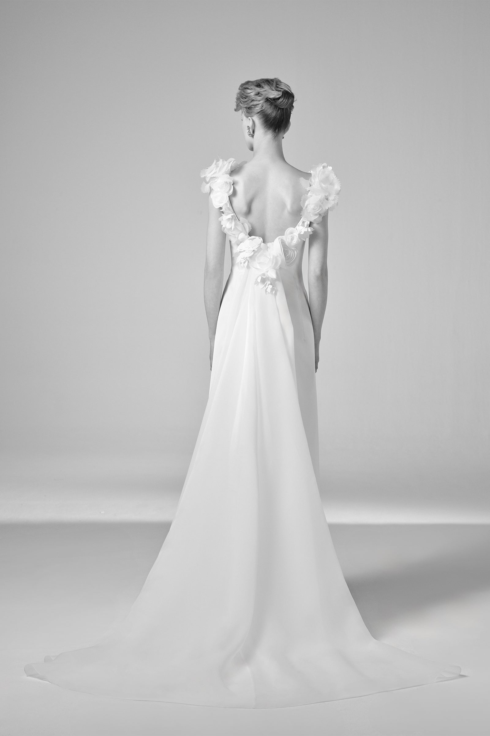 This elegant double crepe column gown is elevated by a detachable organza watteau train that adds dramatic flair, from the Viktor&Rolf Mariage collection.