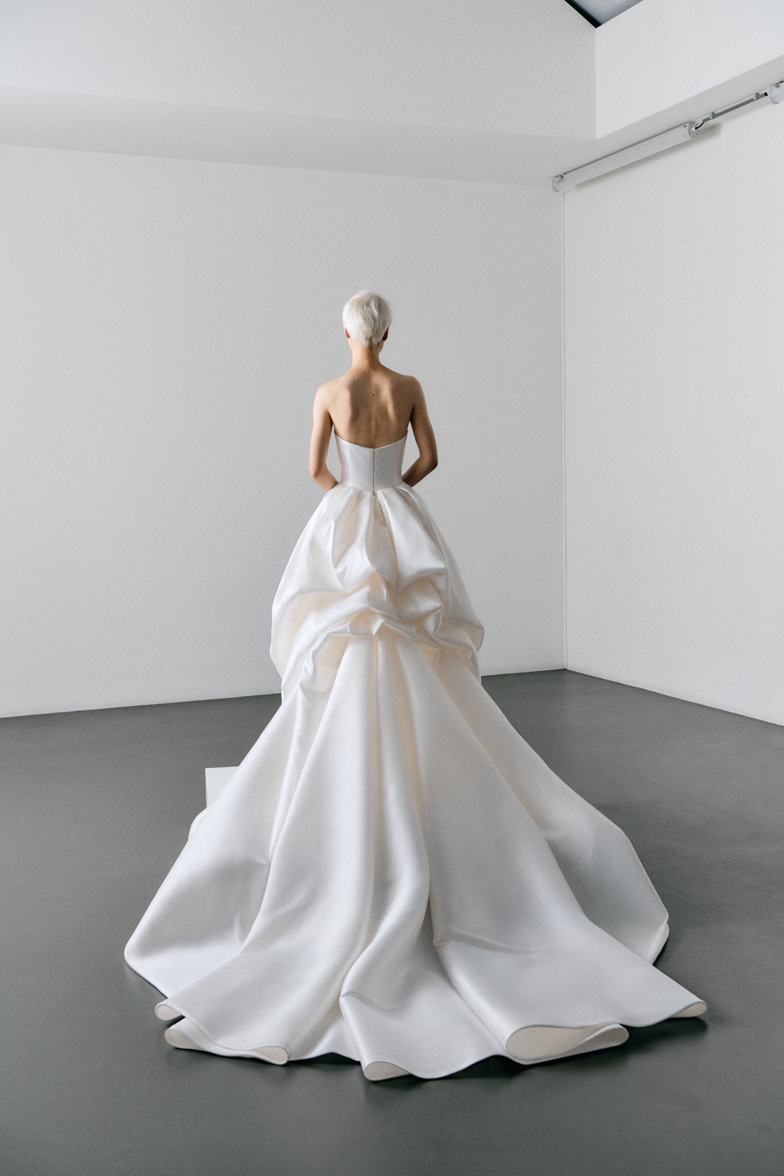 White wedding dress on a model in a minimalistic room.