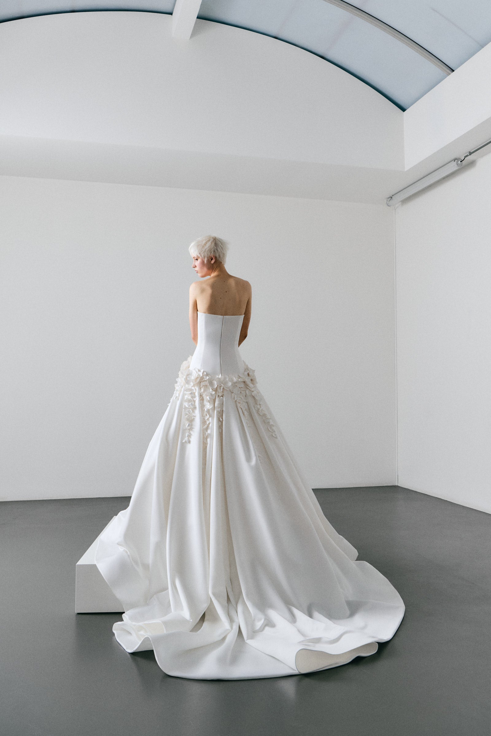 White wedding dress on a mannequin in a minimalistic room.